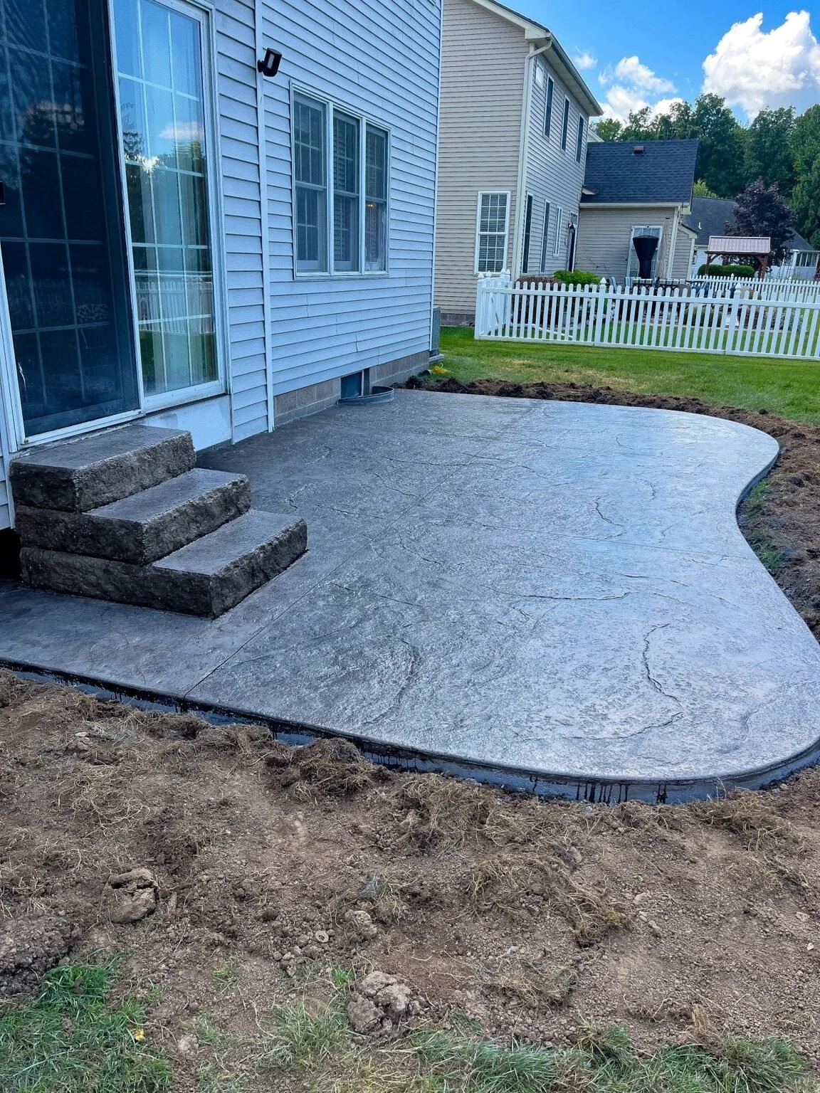 Greece, NY — slate-textured concrete steps with rock-face risers and a dark charcoal color.