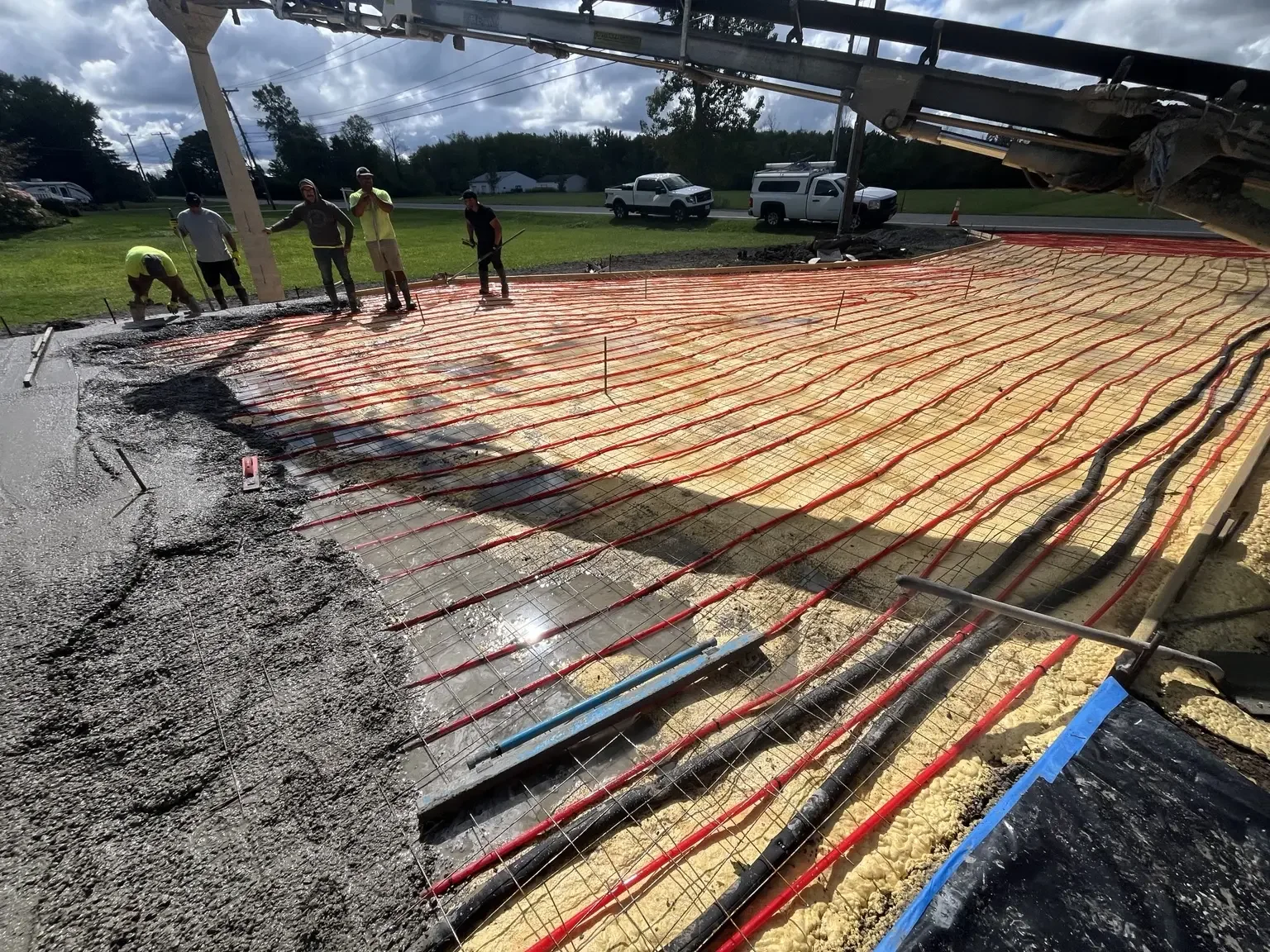 Hydronic hot-water tubing installed over insulation before a heated concrete driveway pour in Webster, NY