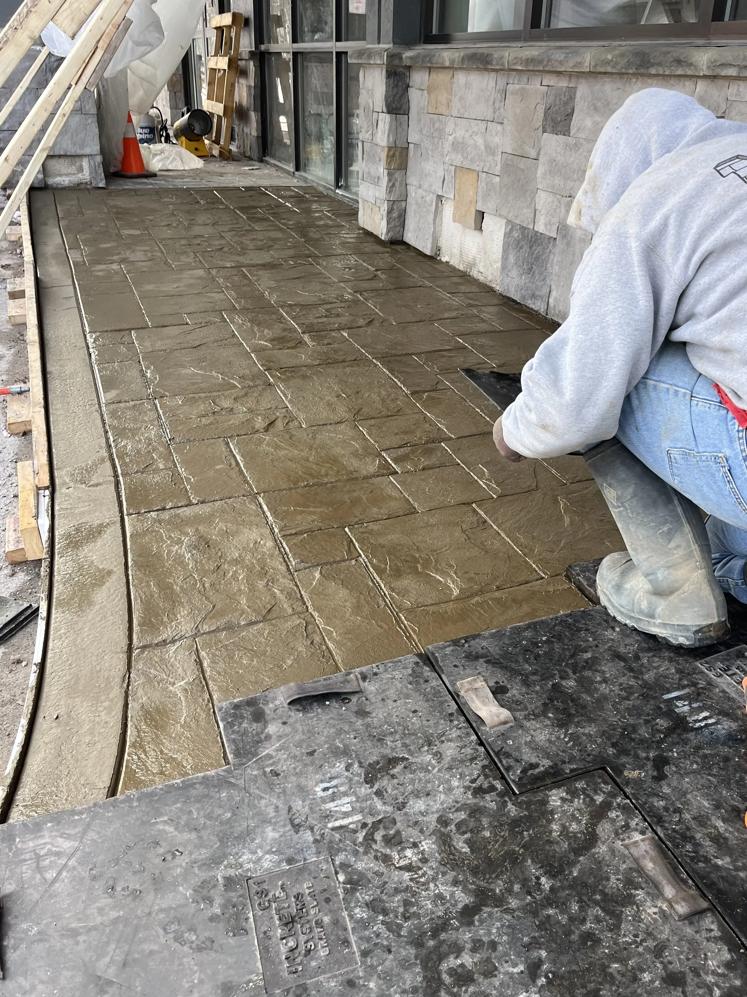 A grand slate stamped sidewalk with a curb in Rochester, NY
