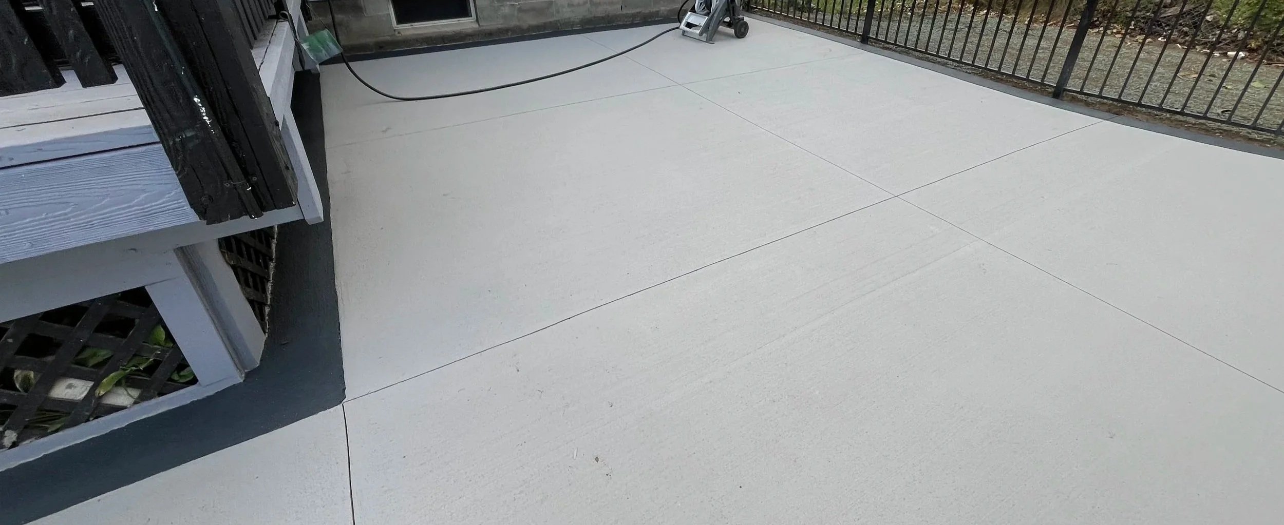 A broomed concrete patio with a dark border near a pool in Rochester, NY
