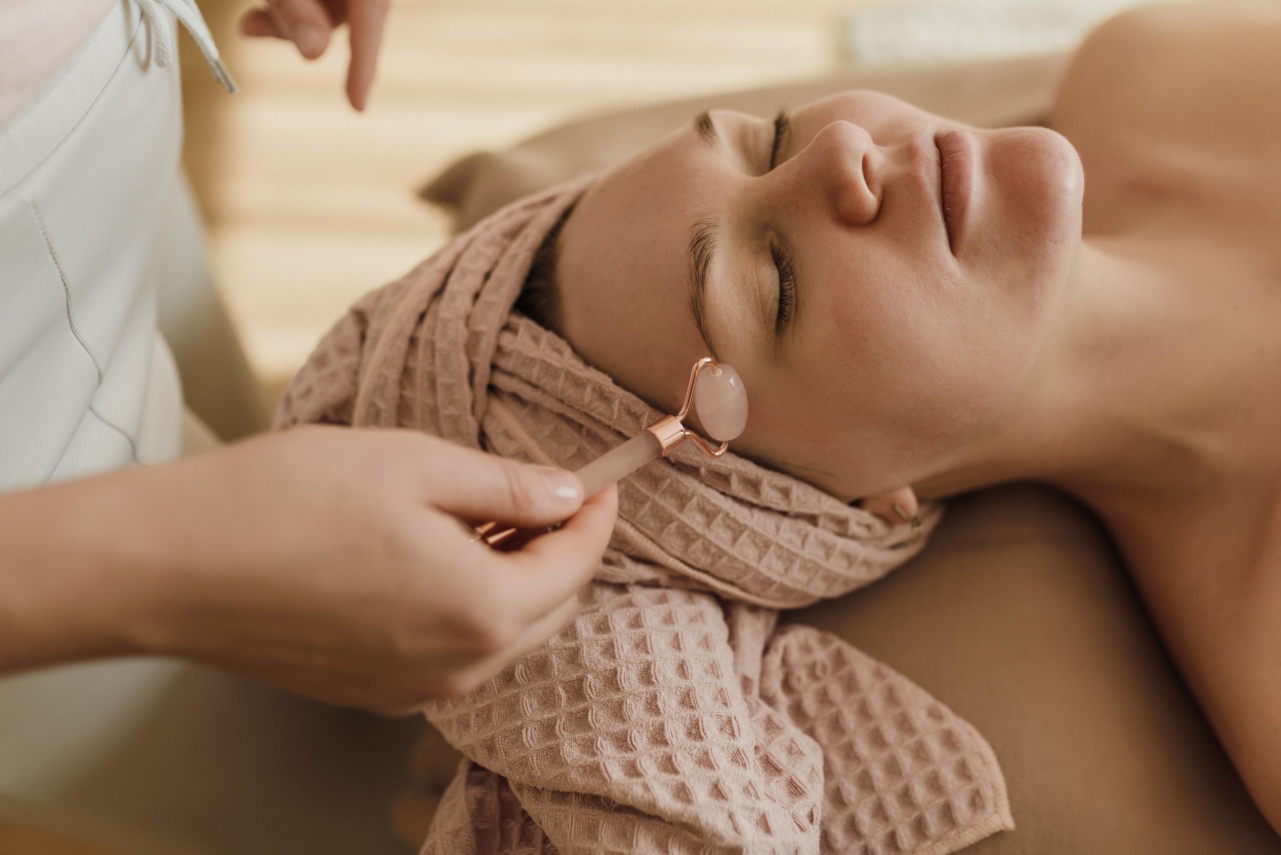 Woman having her face rollered by a therapist
