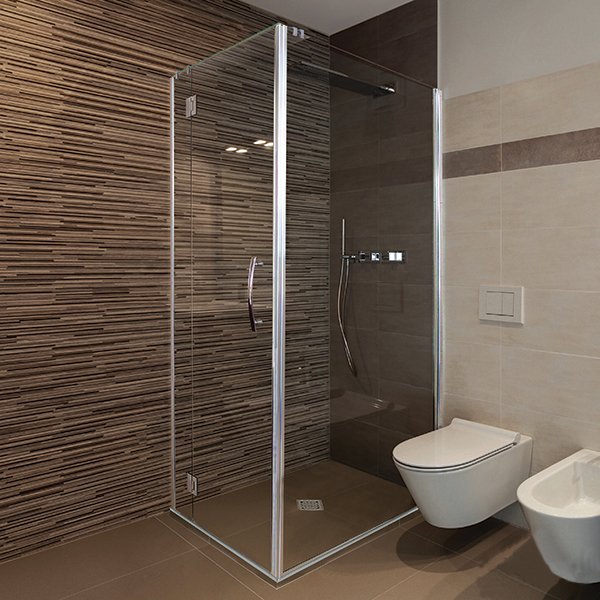 Modern bathroom with glass shower enclosure, textured stone wall, and wall-mounted toilet.