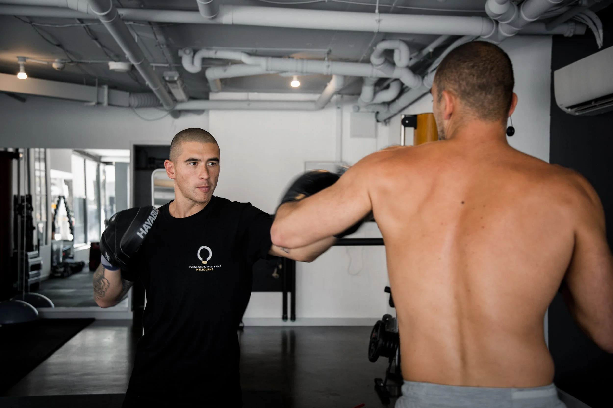 Functional Patterns Melbourne trainer guiding a client through boxing drills, improving posture, coordination, and functional strength.