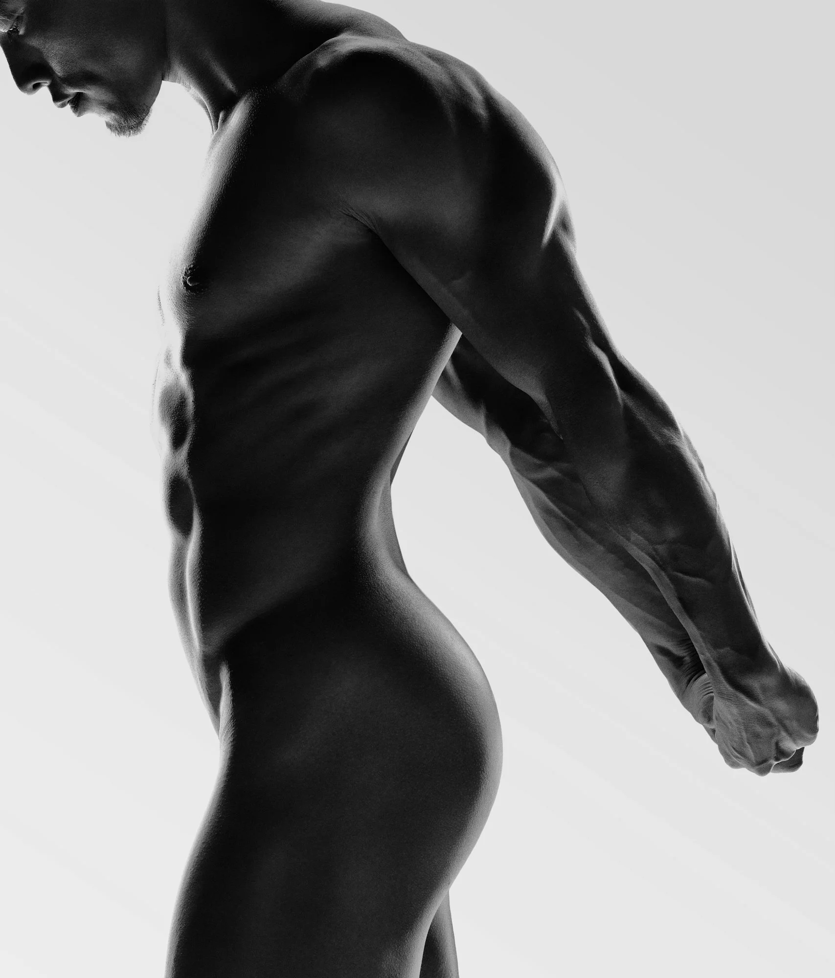 A male fitness-model in semi silhouette lighting 