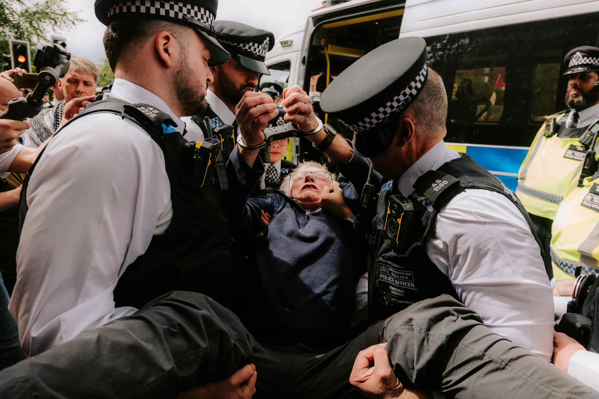 Police officers carry away an elderly man after arresting him outside Woolwich Crown Court for holding a sign in support of proscribed group Palestine Action. 