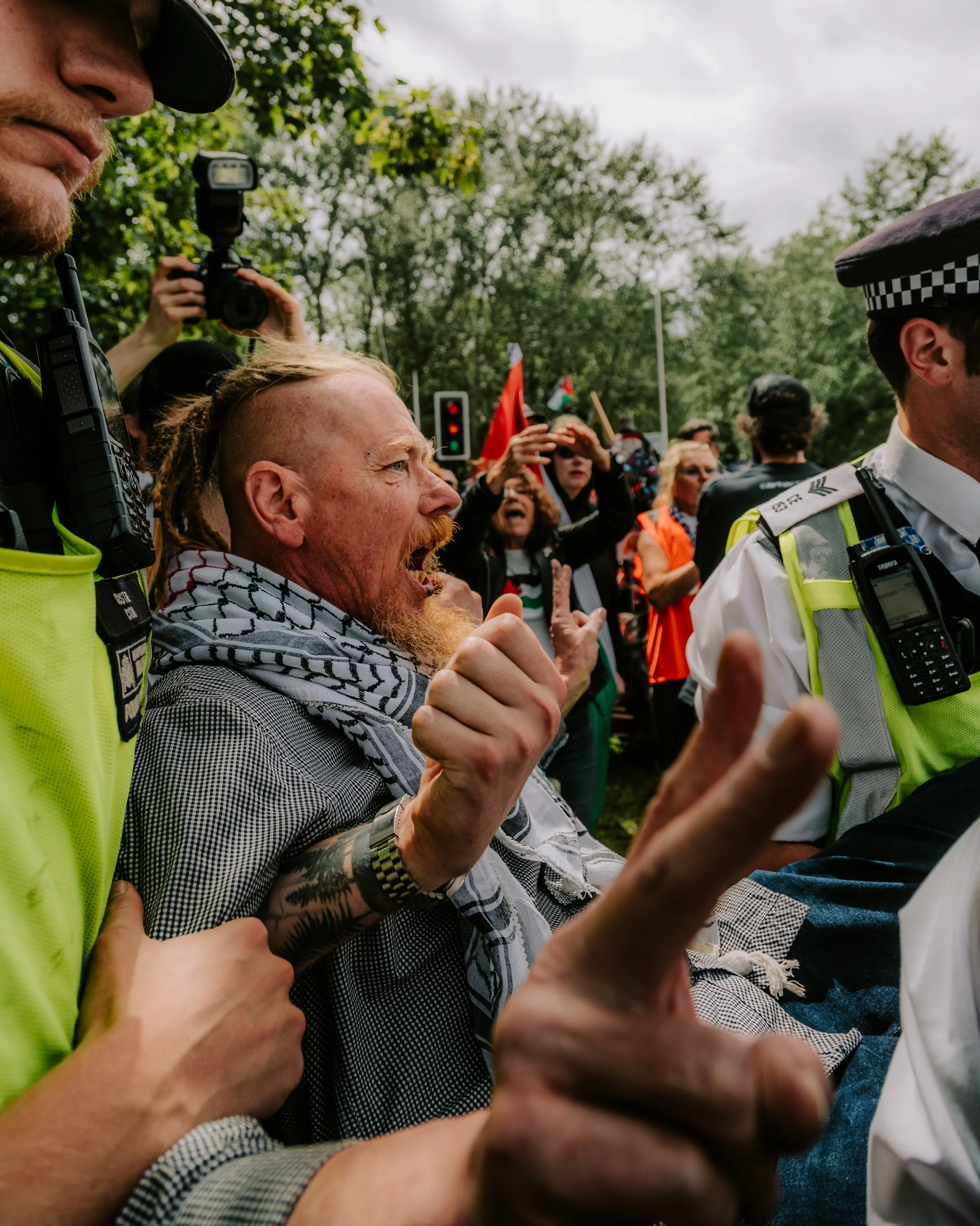 Police officers carry away an elderly man after arresting him outside Woolwich Crown Court for holding a sign in support of proscribed group Palestine Action. 