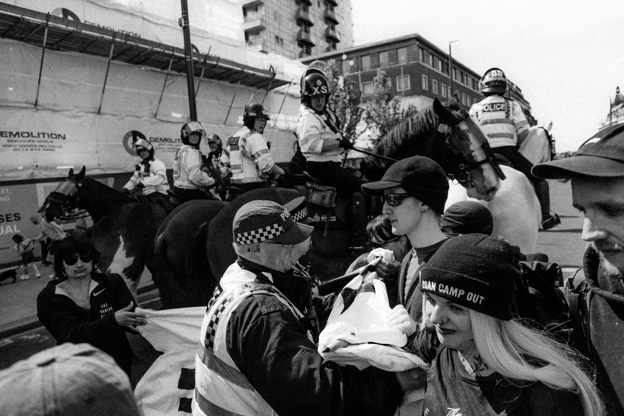 A group of police officers on horseback and on foot push anti-fascist protesters trying to block UKIP marching in Leeds City Centre