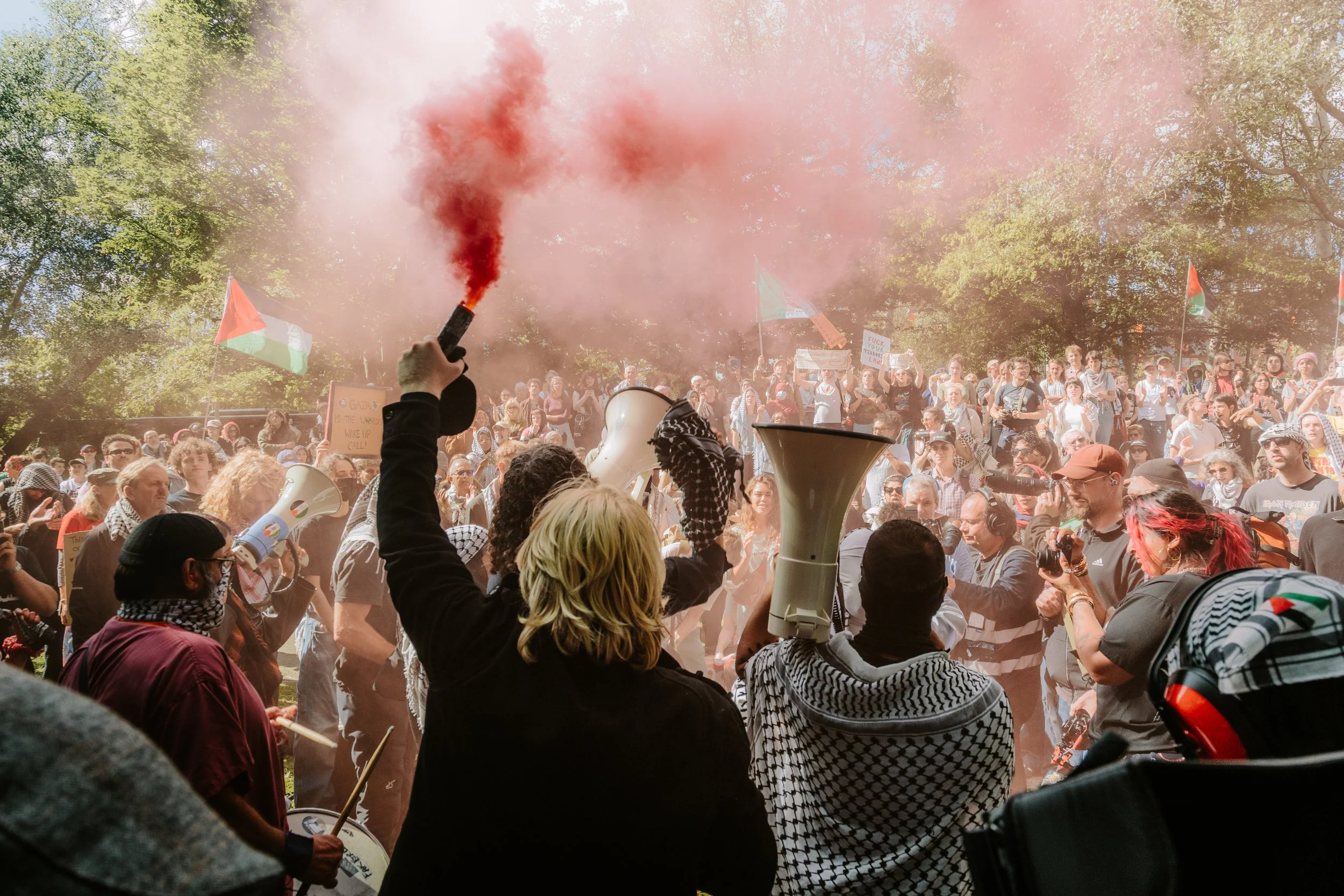 Pro palestine protesters outside Woolwich crown court holding flares.