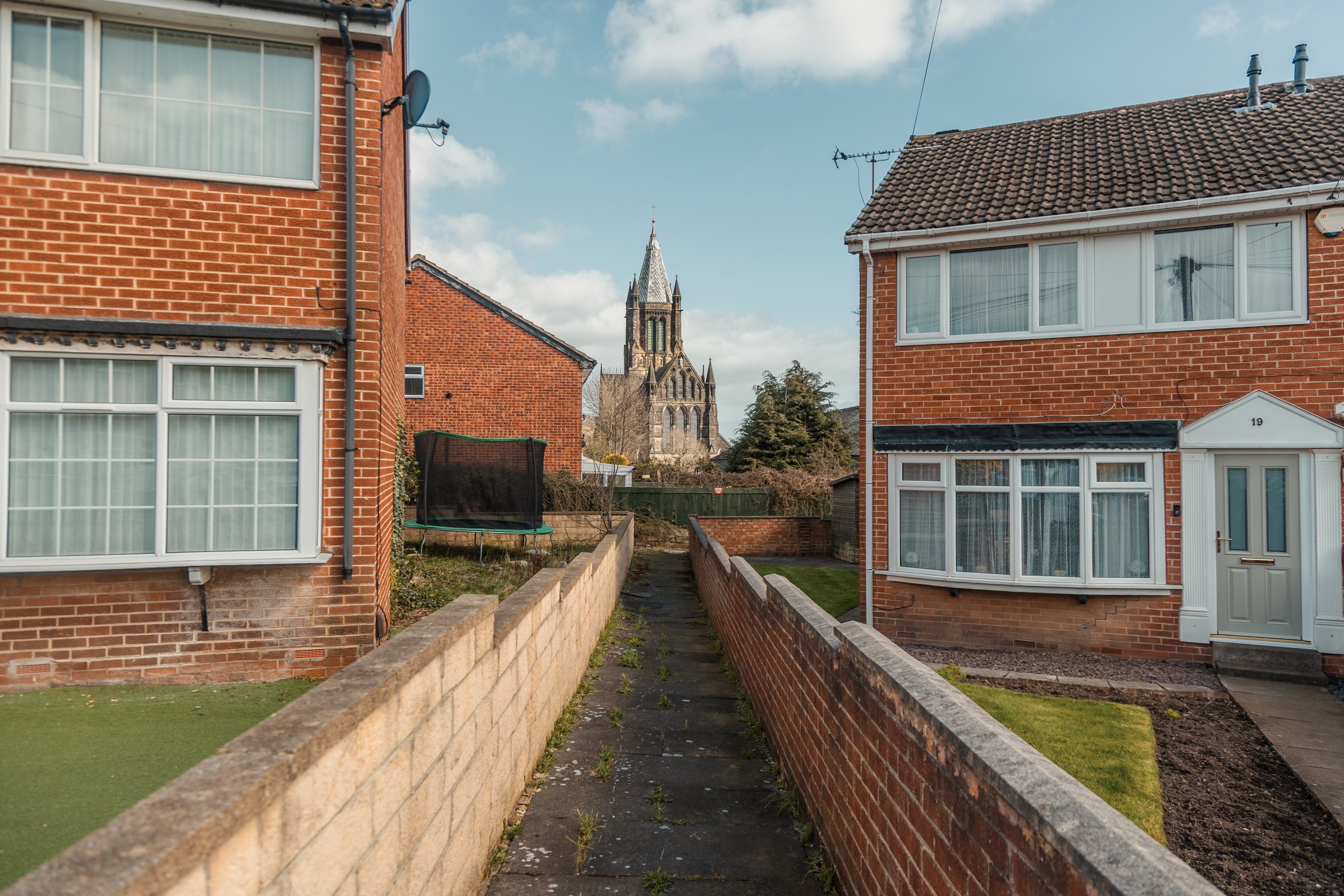 St bartholomews church in armley leeds framed between two residential houses