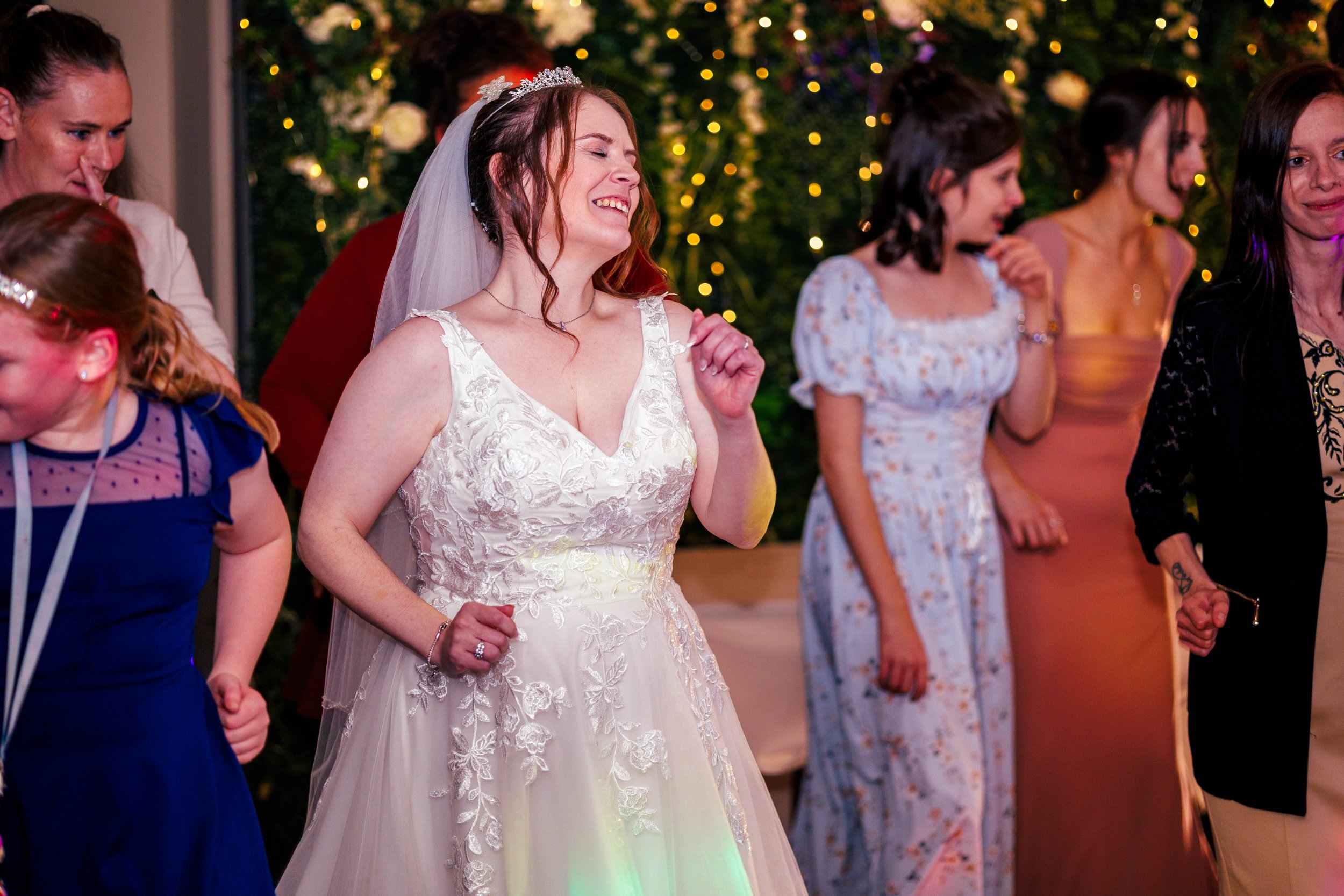 Bride dancing with guests at a wedding reception.