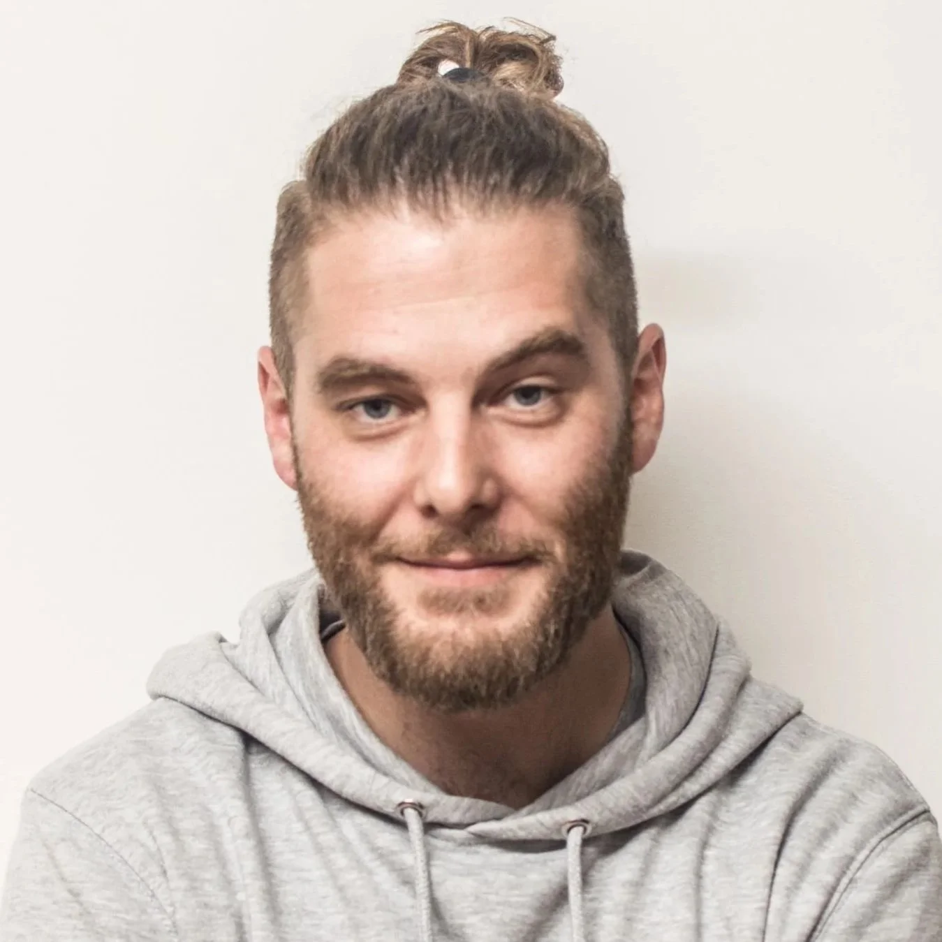 Abstract geometric logo for Pynewood Press with a stylized, symmetrical design in dark green, resembling a cityscape or architectural elements, and the text 'PYNEWOOD PRESS' below.