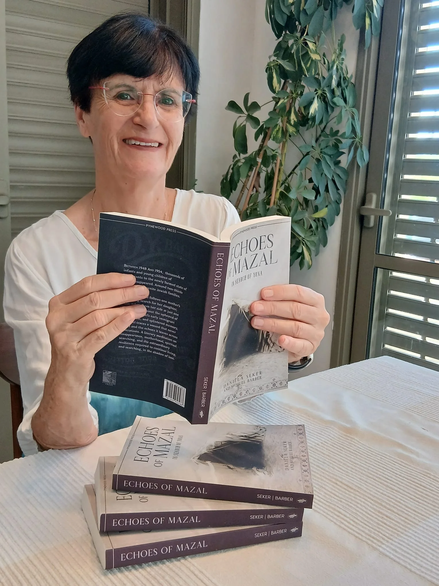 Daniela Seker author of Echoes of Mazal with copies of her book