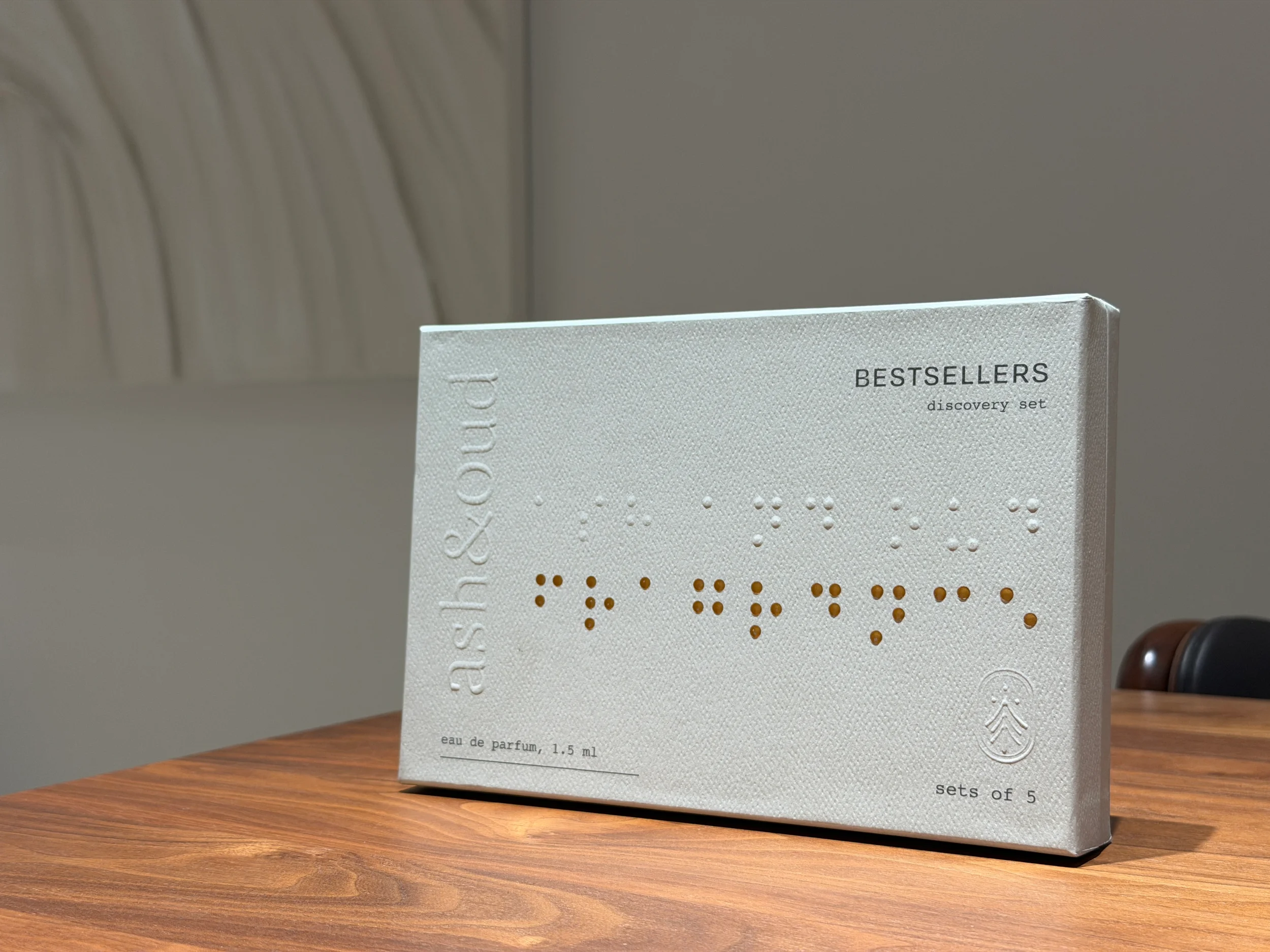A white box of a skincare discovery set with embossed and printed text, placed on a wooden surface.