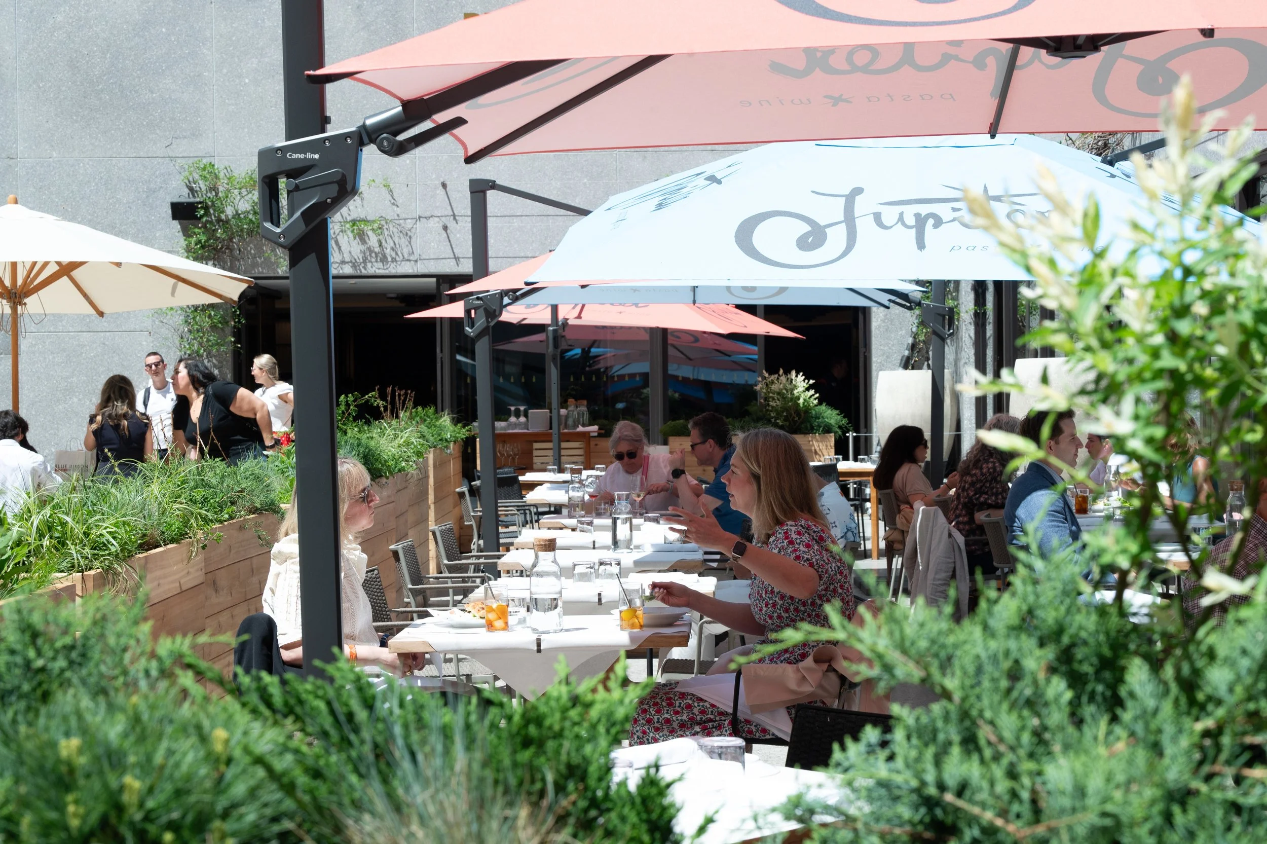 The outdoor terrace at Jupiter Restaurant showing guests sitting at tables enjoying lunch in Midtown, Manhattan.