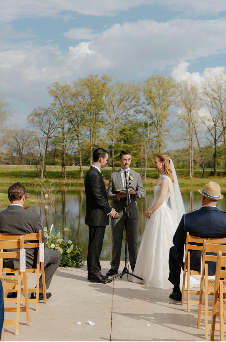 Couple exchanging vows beside the lake at The Eden Estate in Ashland City, Tennessee.