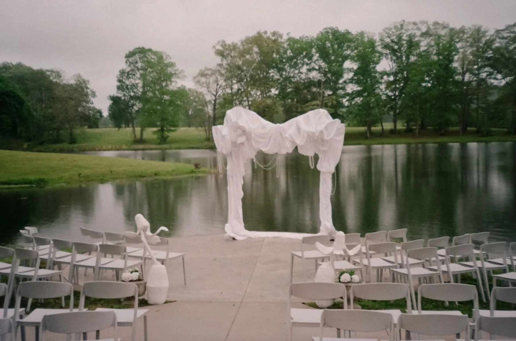 Lakeside wedding ceremony at The Eden Estate in Ashland City, Tennessee, with guests seated beside the water. Photo by Jenna York.