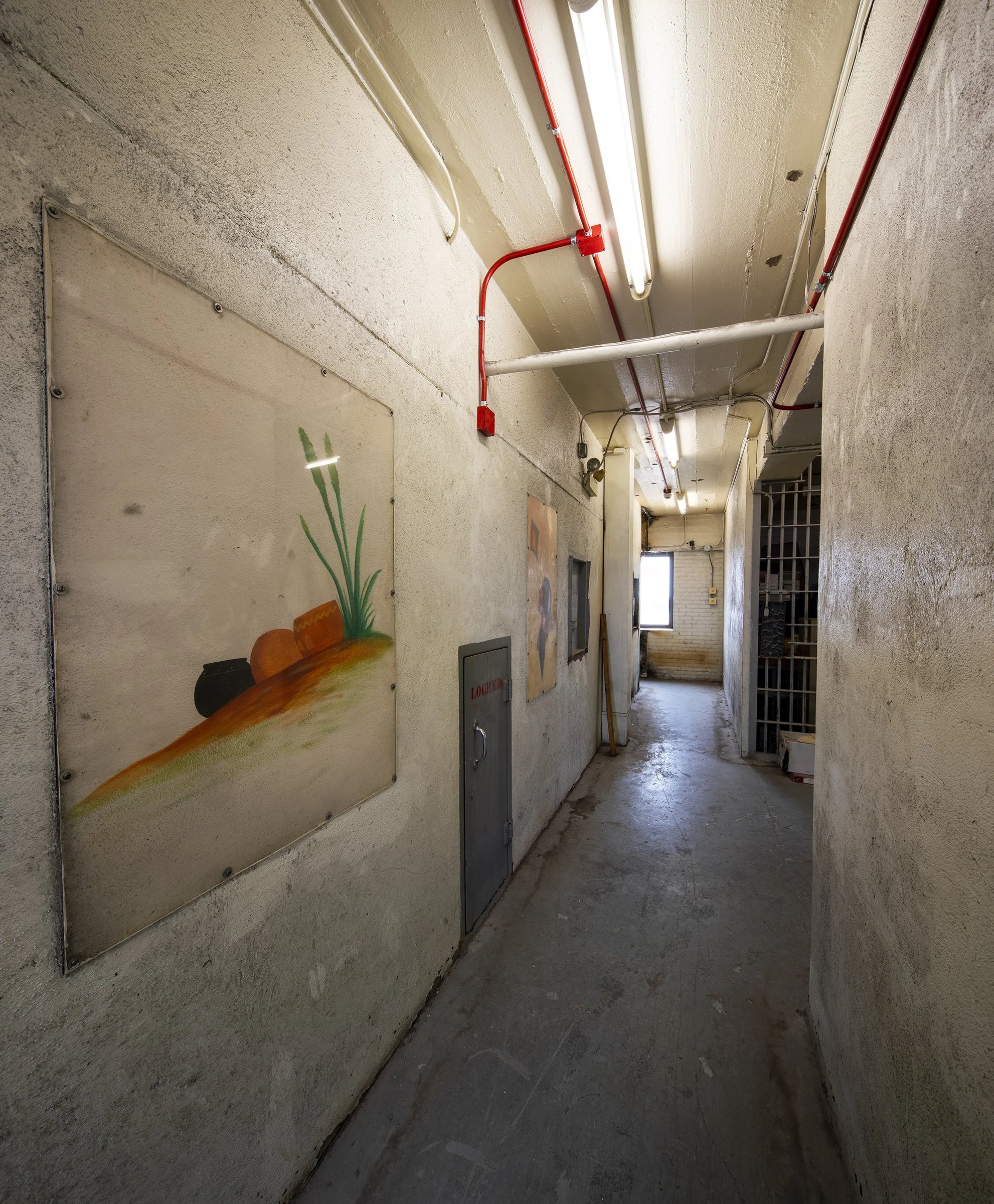 A hallway with artwork by Burgess Roye in the abandoned Garfield County, Oklahoma, Jail.  Awesome Jailhouse Art.