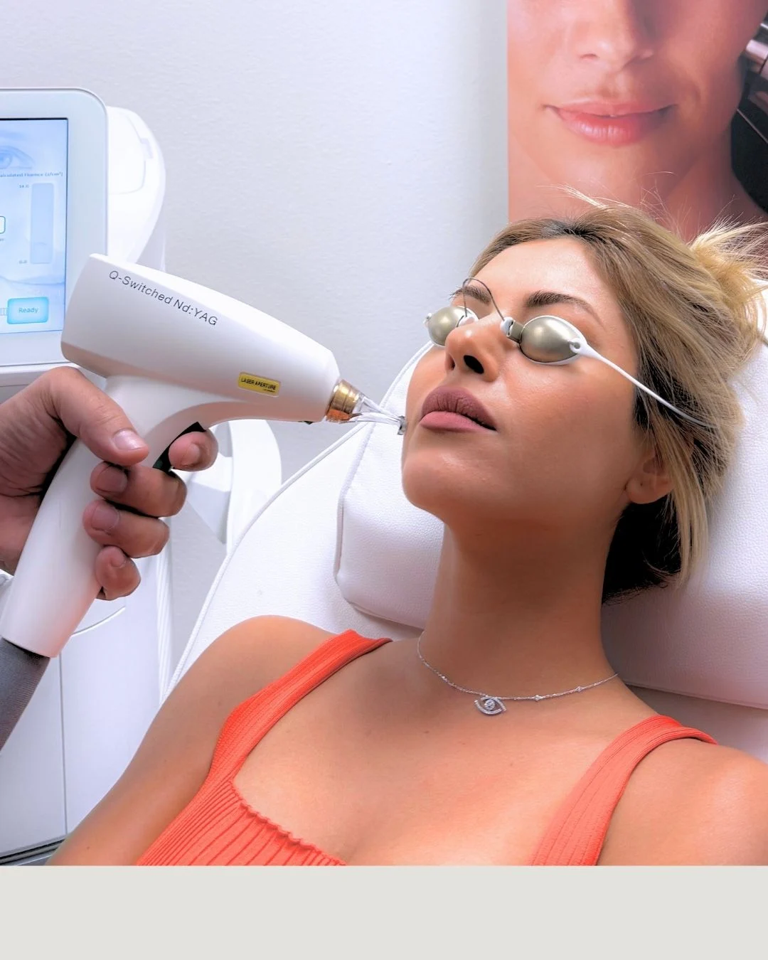 A woman is lying down during a cosmetic treatment, with a technician in gloves applying a device to her face.