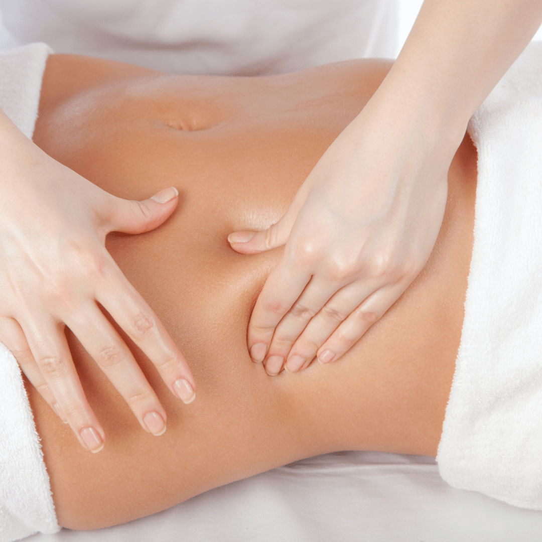 Close-up of a person receiving a massage on their abdominal area, with hands pressing on the skin.