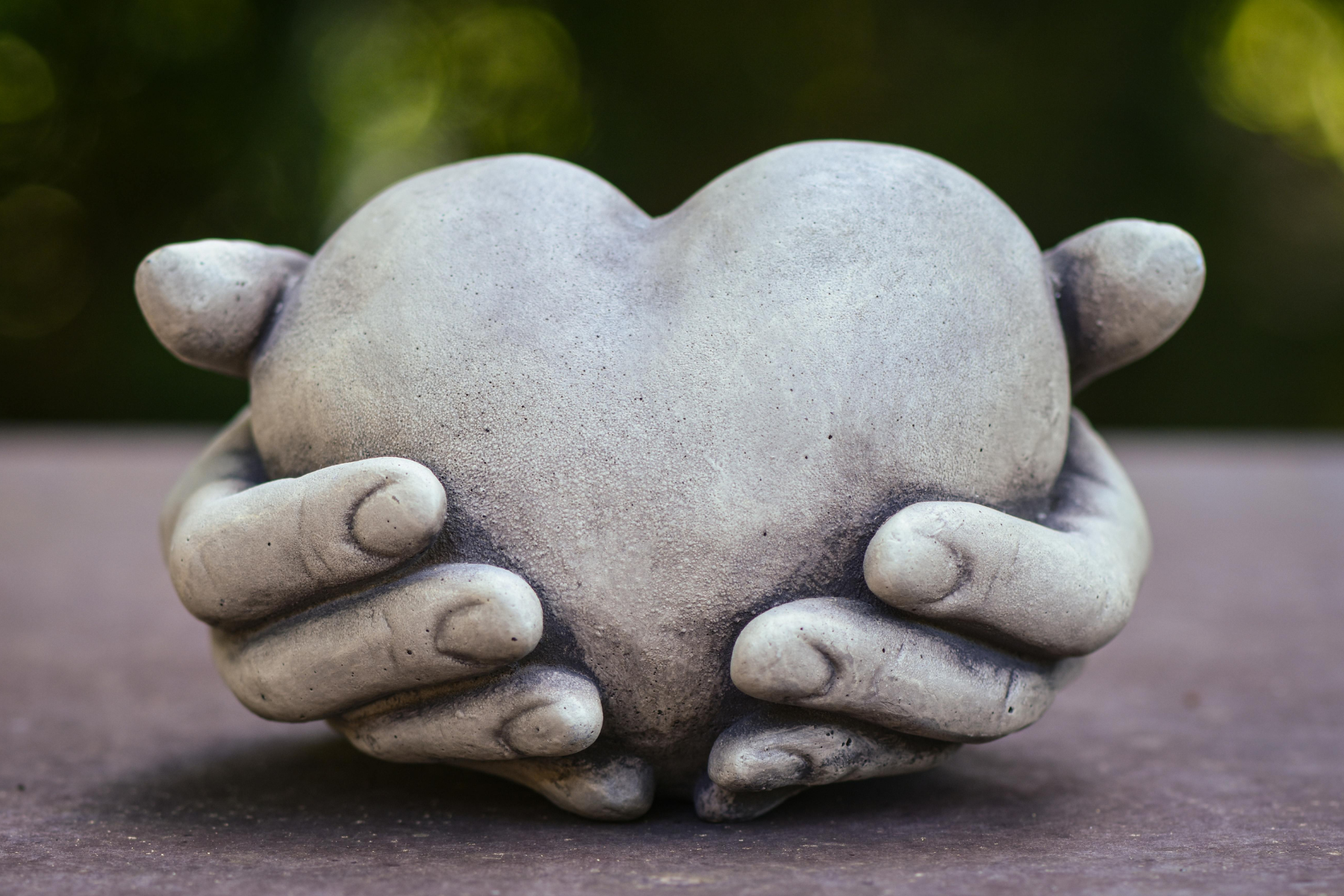 Stone hands holding stone heart