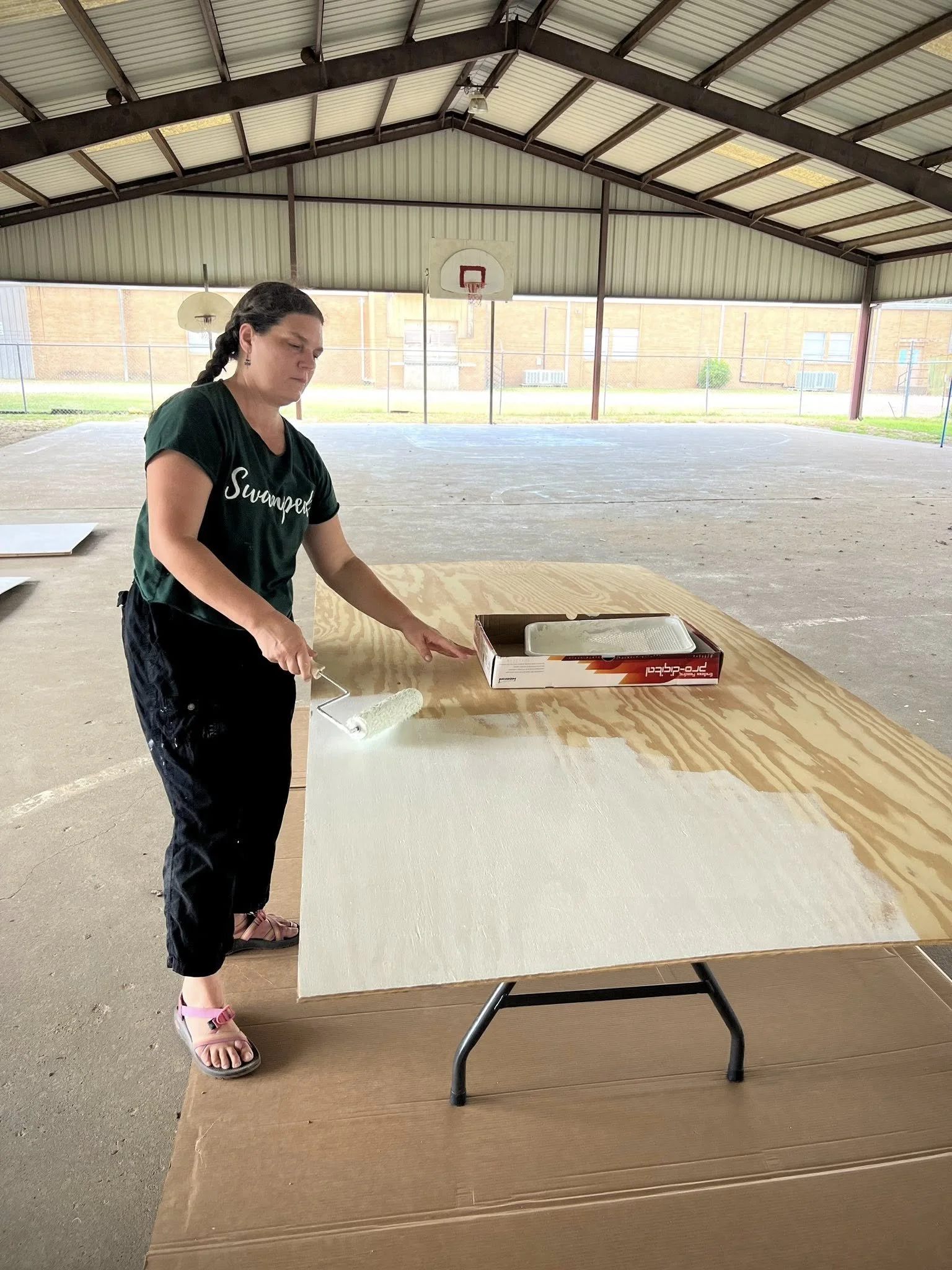 Robin Whitfield paints a panel with white paint