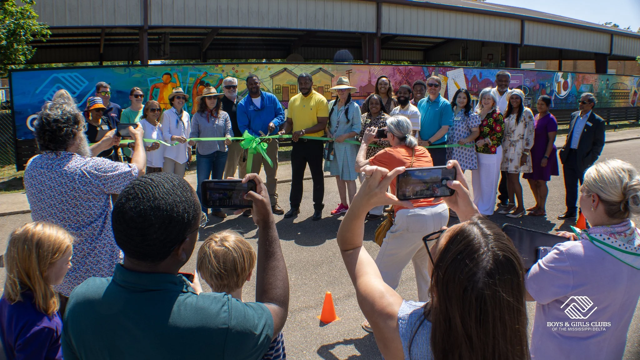 Smile for the cameras! Cutting the ribbon for our new mural in Greenwood.