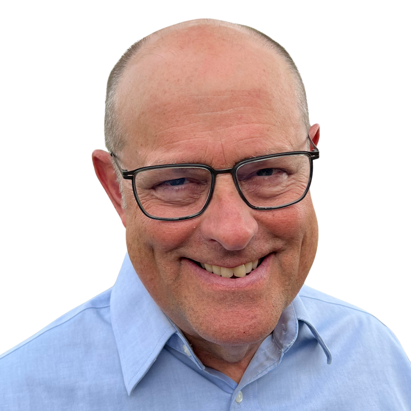 Close-up of smiling middle-aged man with bald head, black-rimmed glasses, light blue dress shirt, and big smile showing teeth.