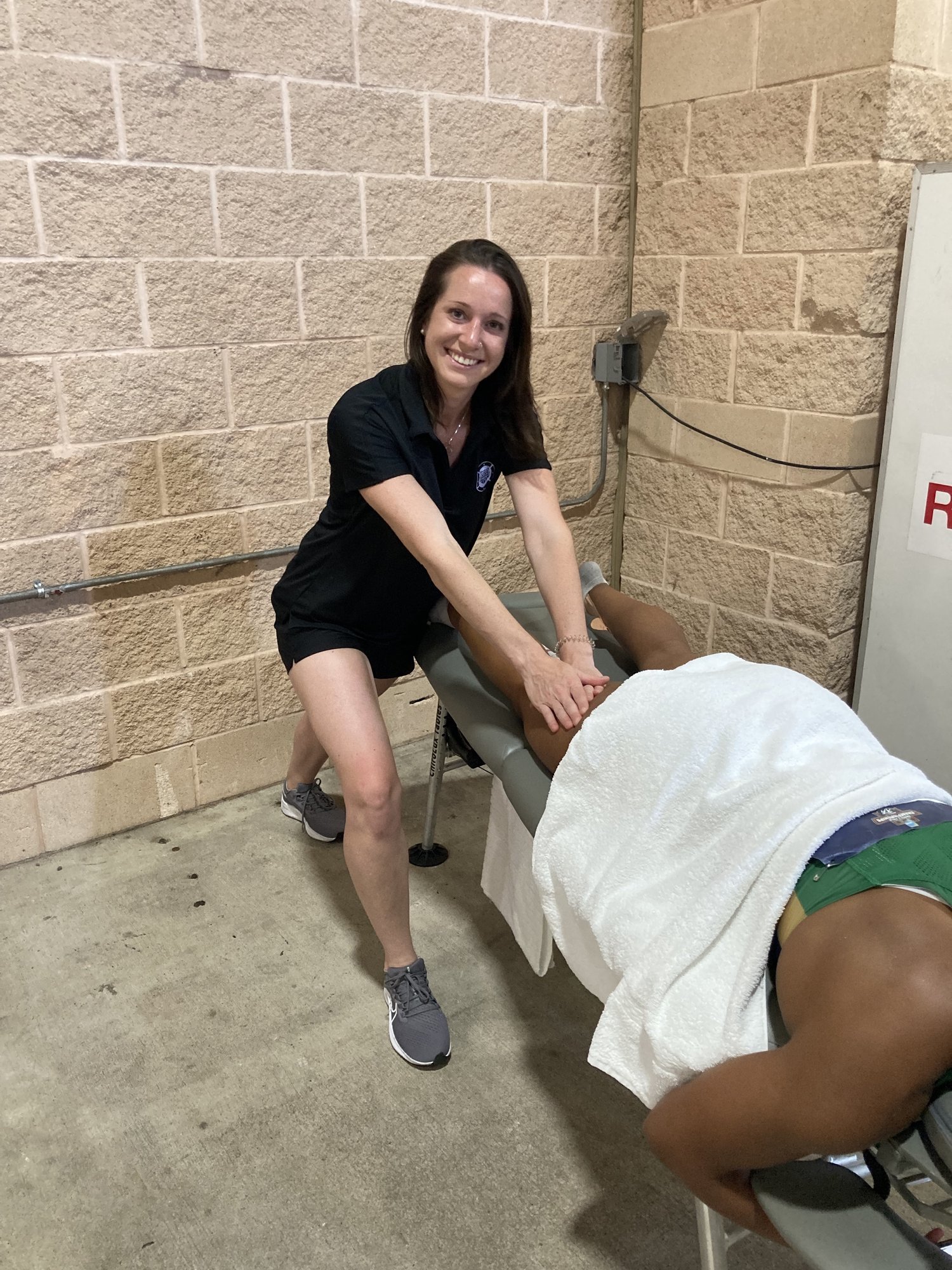 Massage therapist performing sports therapy mid competition.