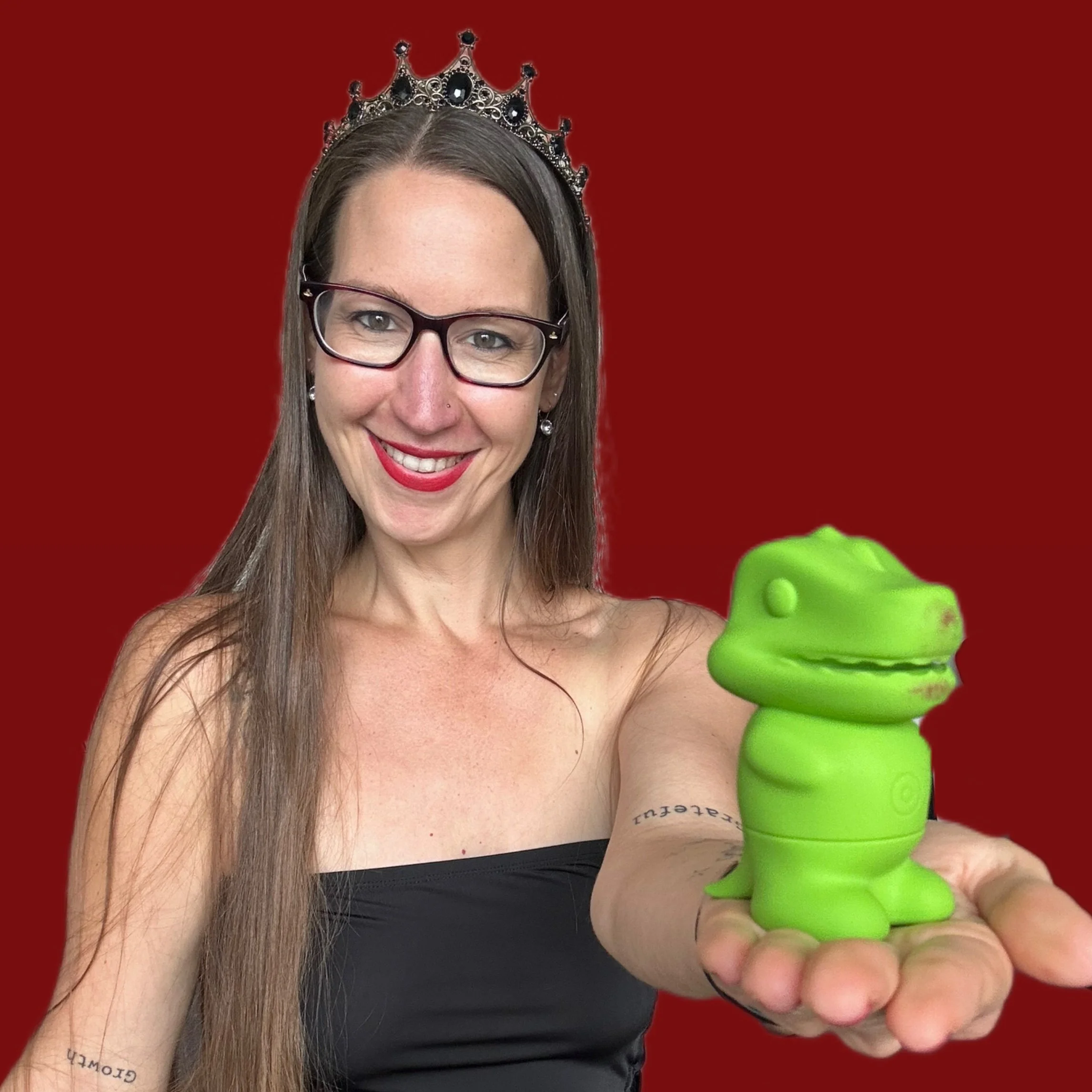 Pleasure Toy Queen Patricia holding a dinosaur clitoral suction vibrator