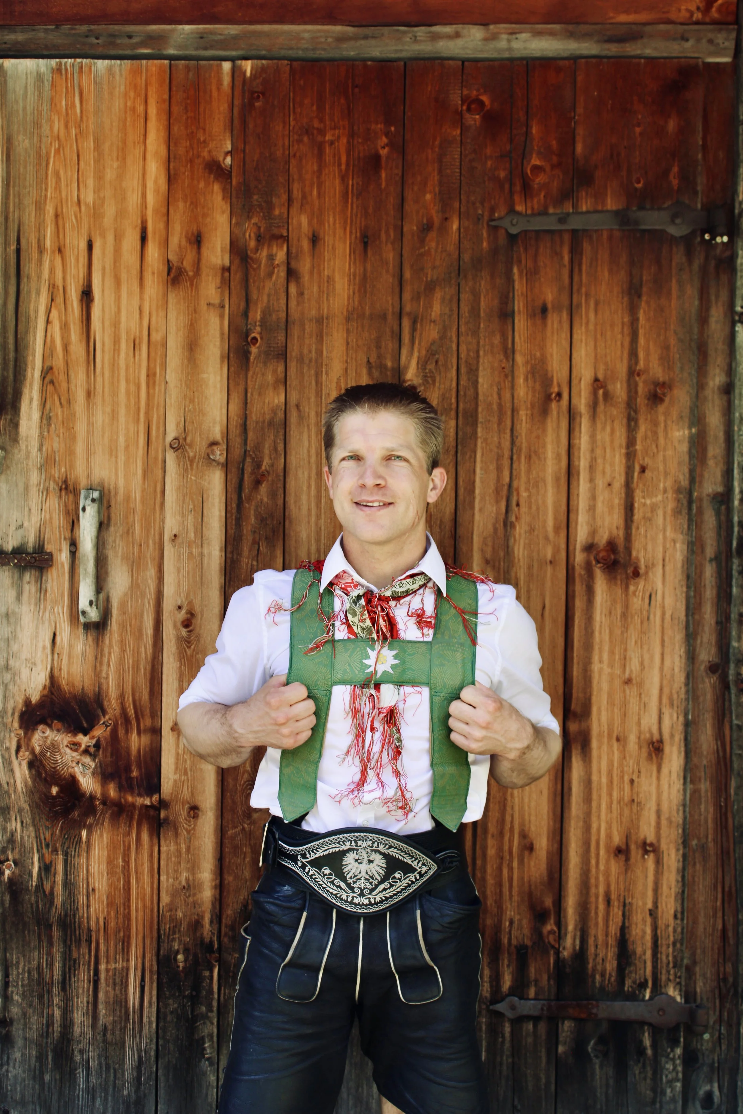 Mann in traditioneller Tracht vor einem Vorhang.
