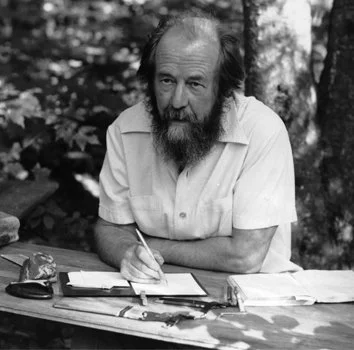 aleksandr solzhenitsyn  at a table outdoors in black and white photo