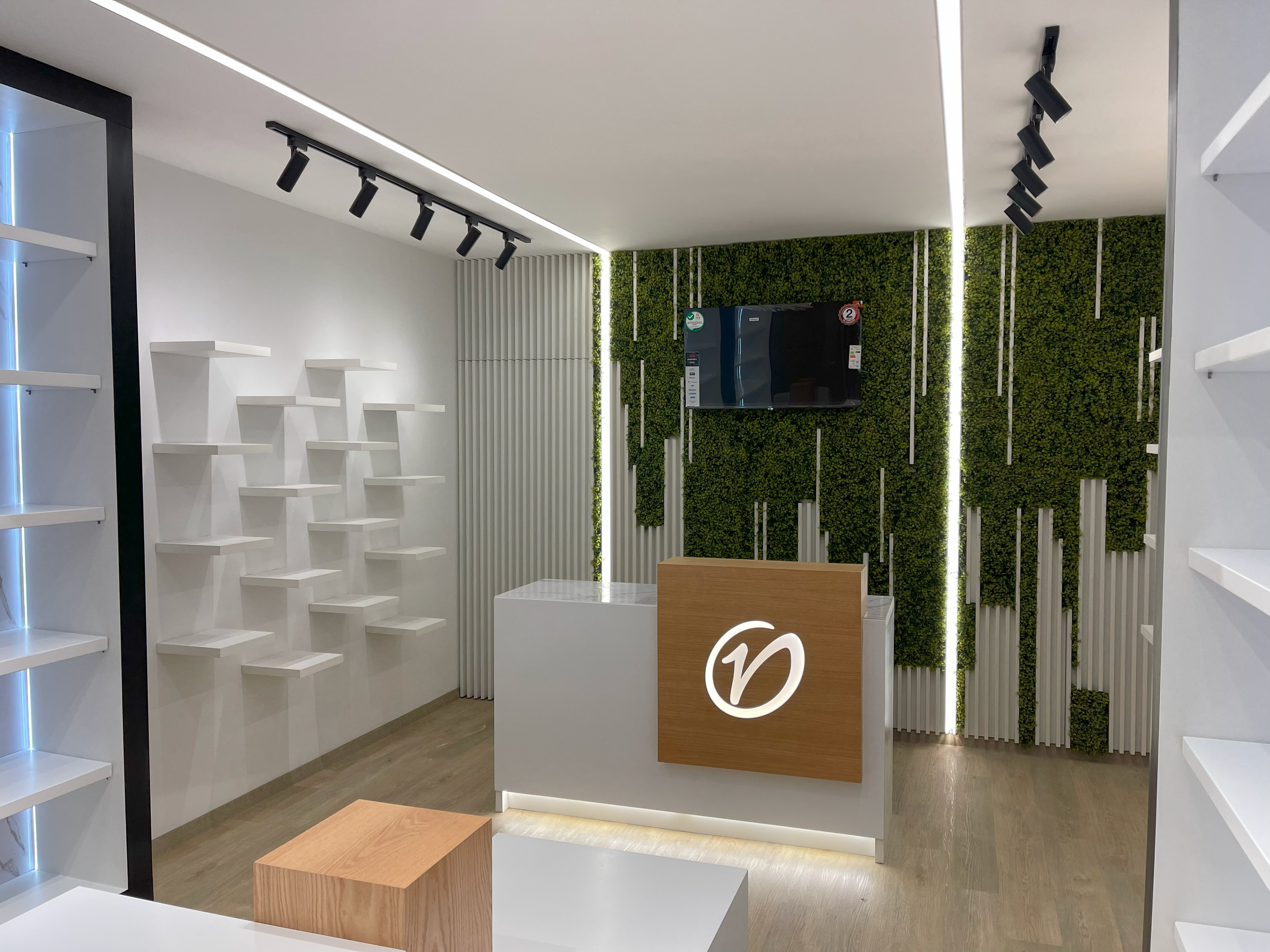 Verssato, experiencia y calidad en el espacio, Quicentro Sur. Utilización de superficies blancas y textura verde, en contraste con la madera. Iluminación led y puntual para muestra de productos.