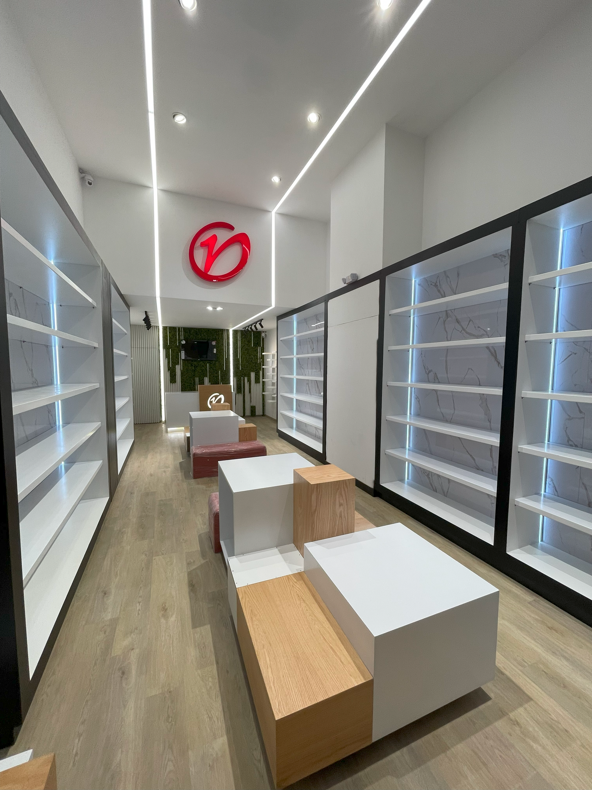 Verssato, experiencia y calidad en el espacio, Quicentro Sur. Utilización de superficies blancas y textura verde, en contraste con la madera. Iluminación led y puntual para muestra de productos.
