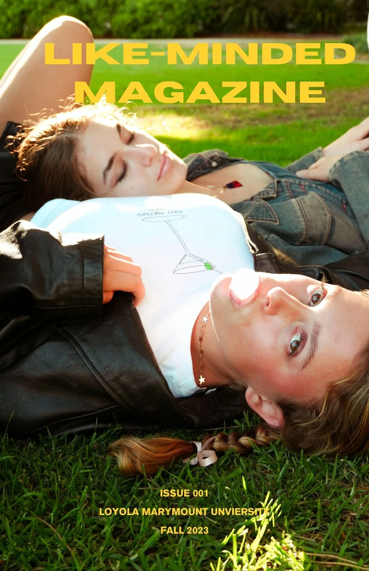 Cover photo of a magazine featuring two young women relaxing on grass in the sunlight. The title reads "LIKE-MINDED MAGAZINE" in large yellow letters. Additional text states: "ISSUE 001, LOYOLA MARYMOUNT UNIVERSITY, FALL 2023."
