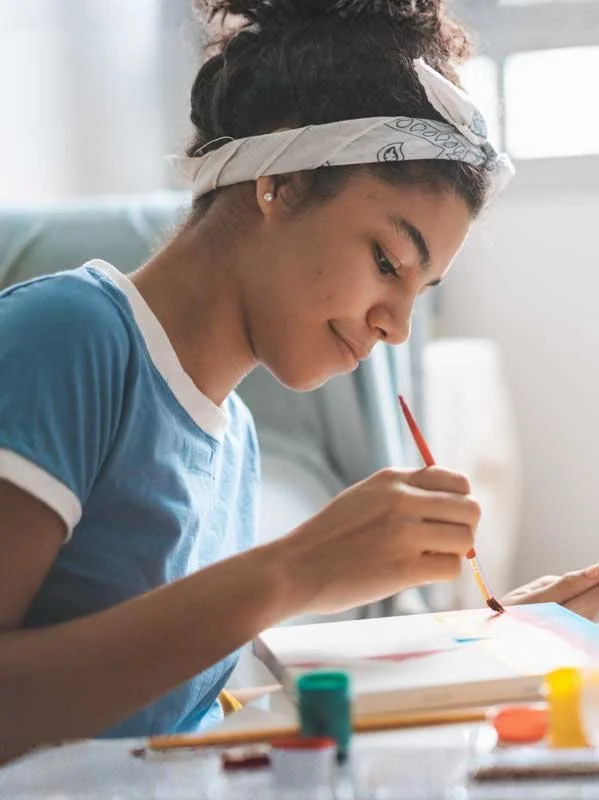 Young woman with a bandana in her hair, wearing a blue shirt, with Advanced Crisis Solution behavioral respite services in California