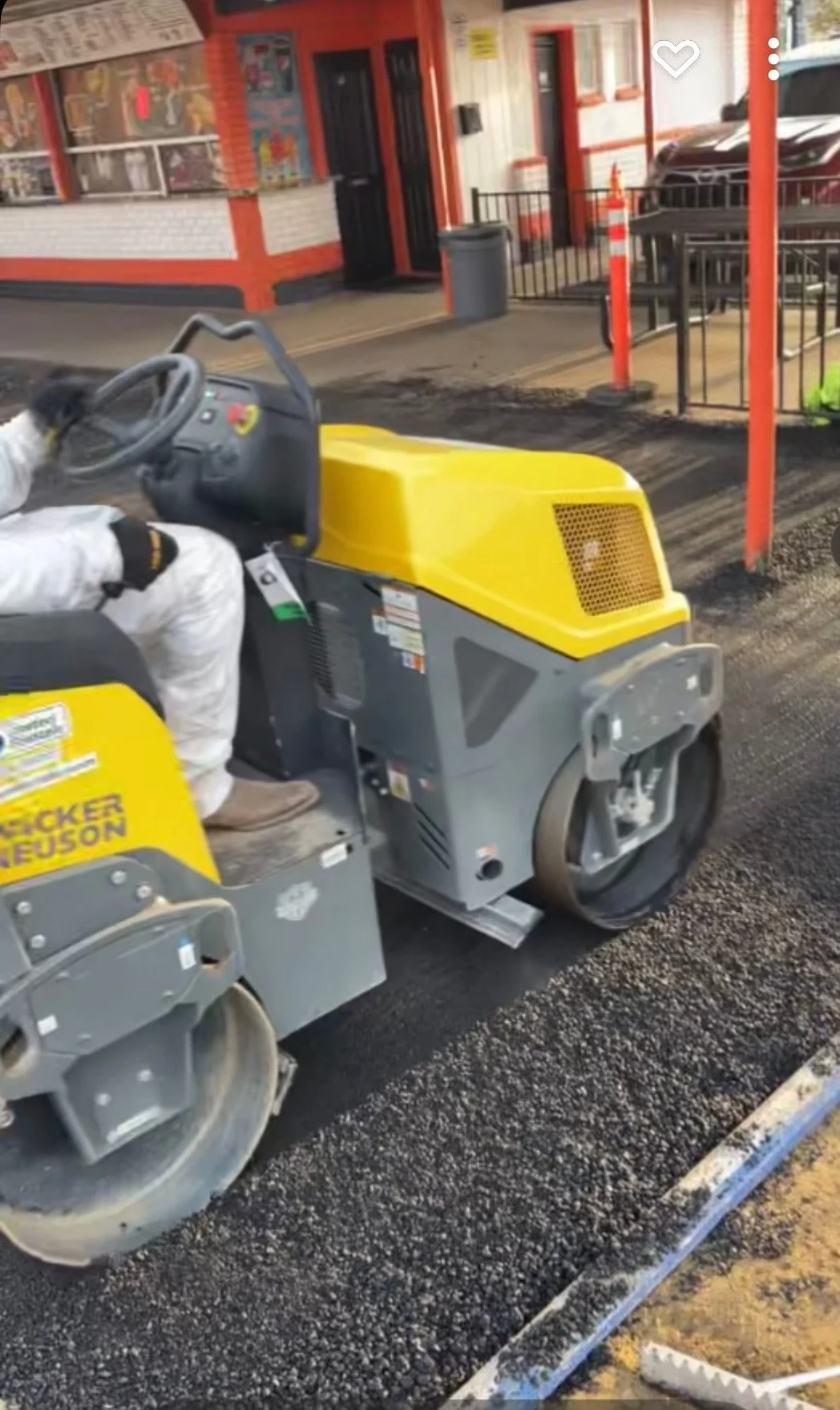 a double drum roller compacting fresh asphalt that had just been laid on top of base