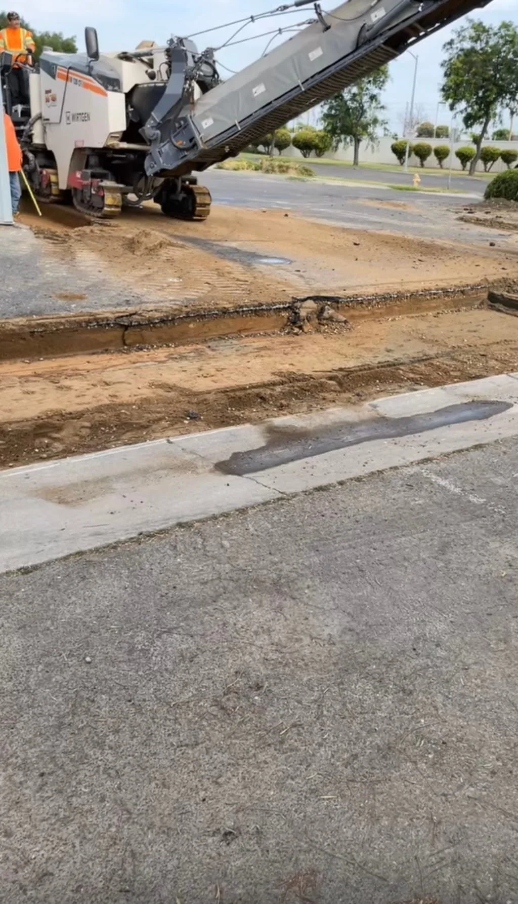 a cold planner grinding out a portion of asphalt all the way down to the base