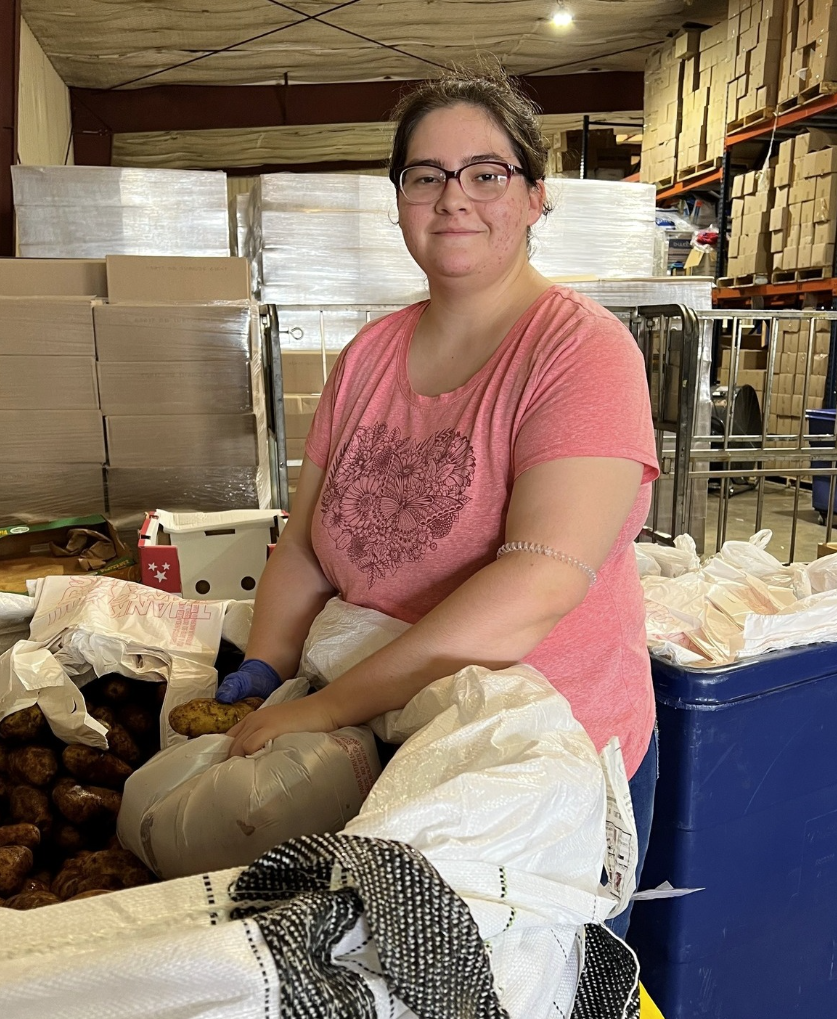 Volunteer filling bags with potatoes