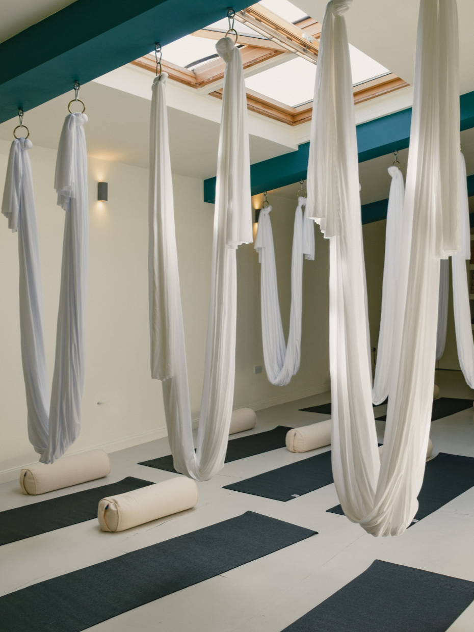 The studio floor with hammocks, mats and bolsters