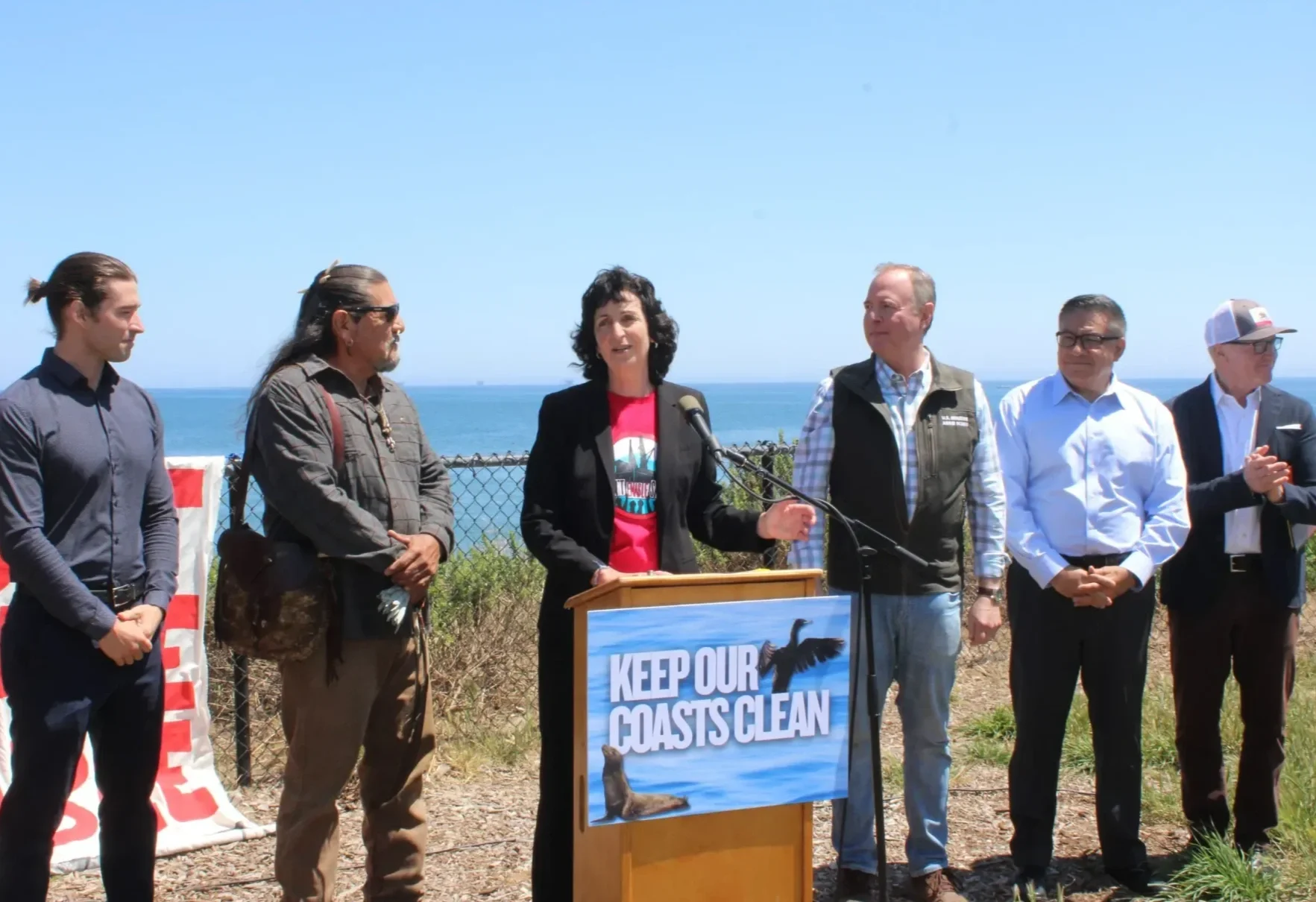 Mati Waiya stands next to Linda Cropp, Adam Schiff, Salud Carbajal, Greg Hart and Brady Bradshaw during a press release.