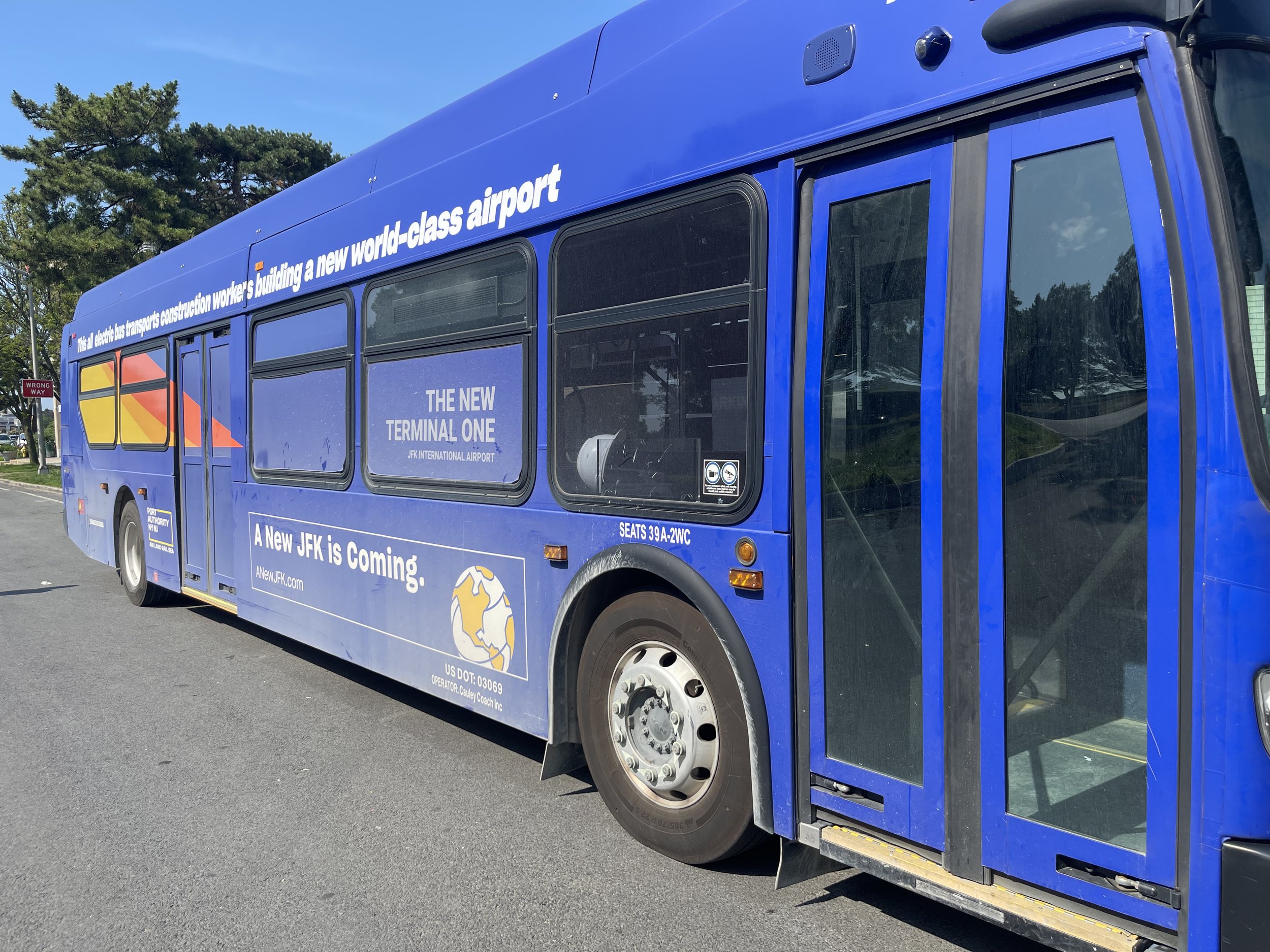 Blue bus with signage advertising the construction of a new world-class airport.