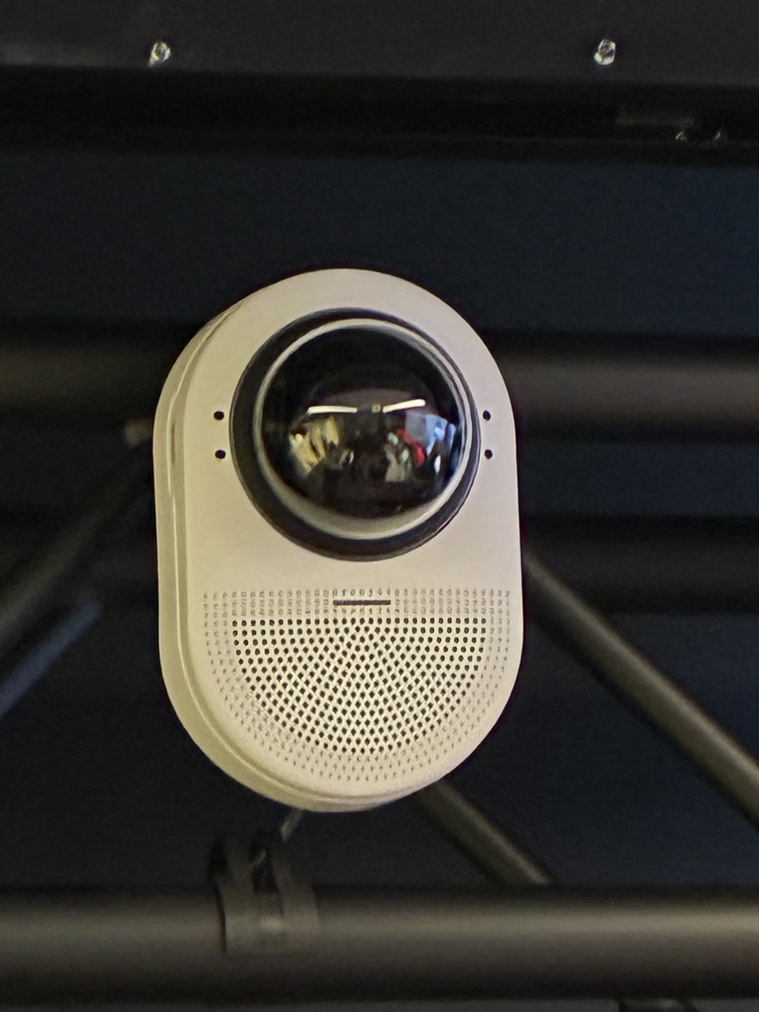 Close-up of a security camera mounted on a black surface.