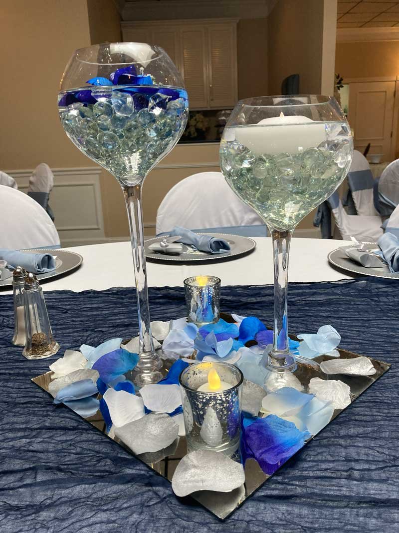 Two glasses of champagne on a decorated table at a celebration or event.