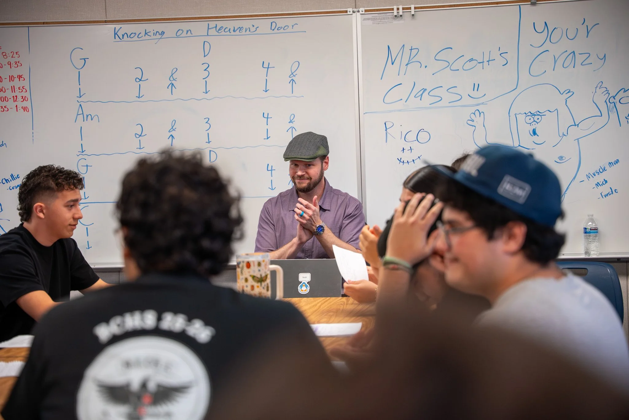 Students in a classroom with teacher clapping