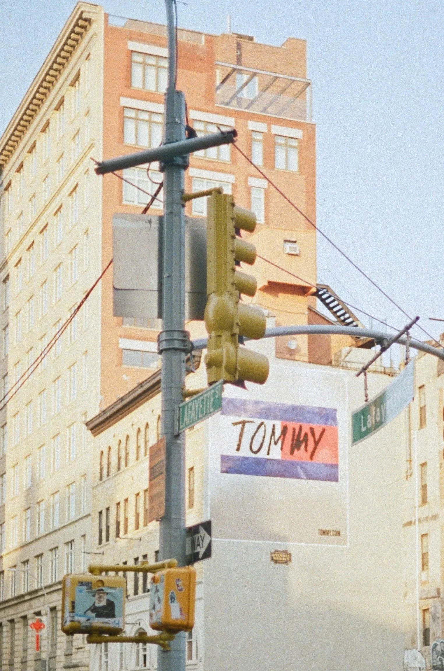 Street corner with traffic light, street signs for Lafayette and Lo Boi, and a colorful campaign sign for Tom Huy hanging on a pole.