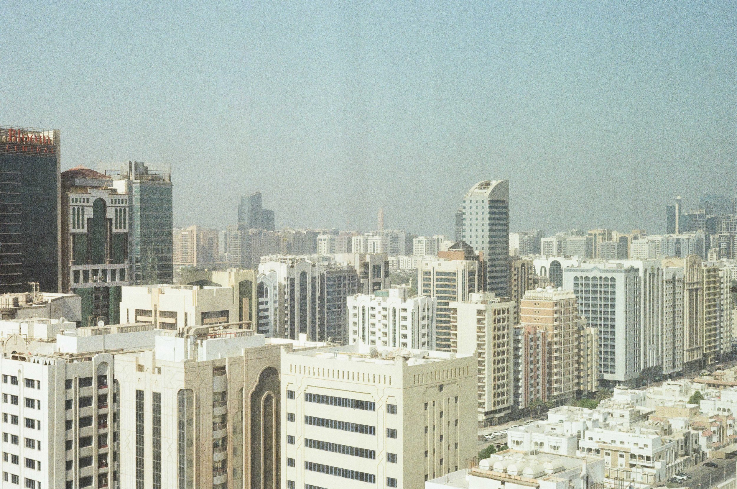 A city skyline with numerous high-rise buildings under a hazy sky.