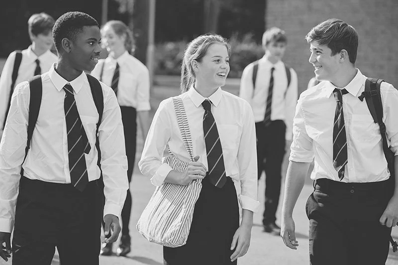 group of teenage students in uniform outside school