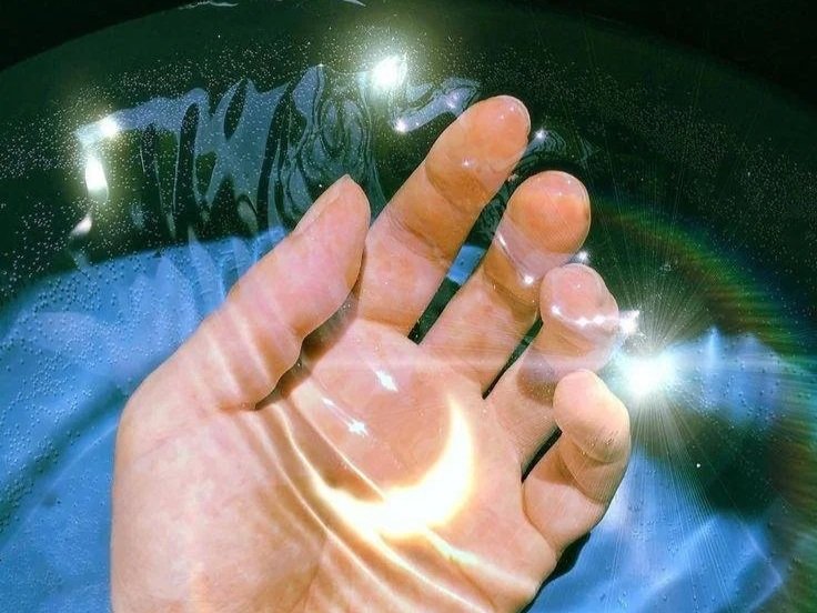 Astrology, moon, spiritual, ritual, ceremony, priestess Close-up of a human hand touching a glass surface with sunlight reflections and a rainbow lens flare.