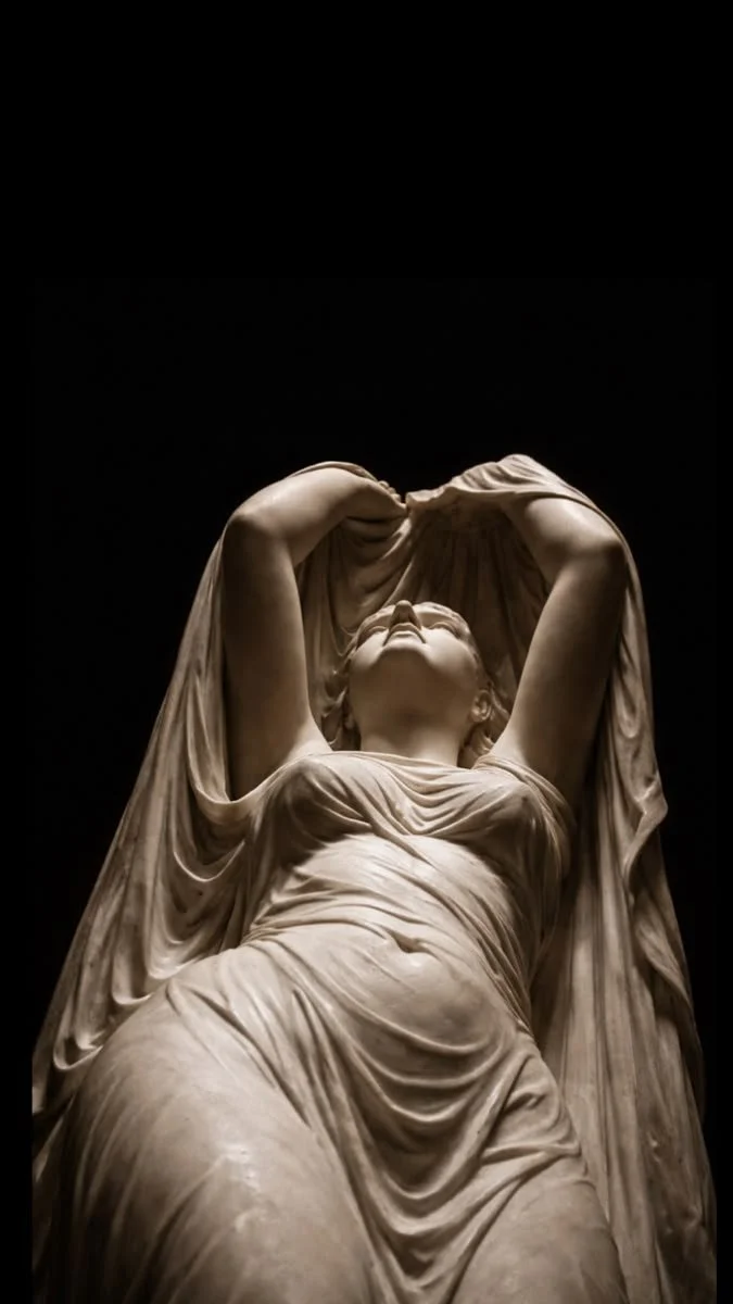 Close-up view of a classical marble sculpture of a woman with her arms raised above her head, wearing draped clothing, against a dark background.