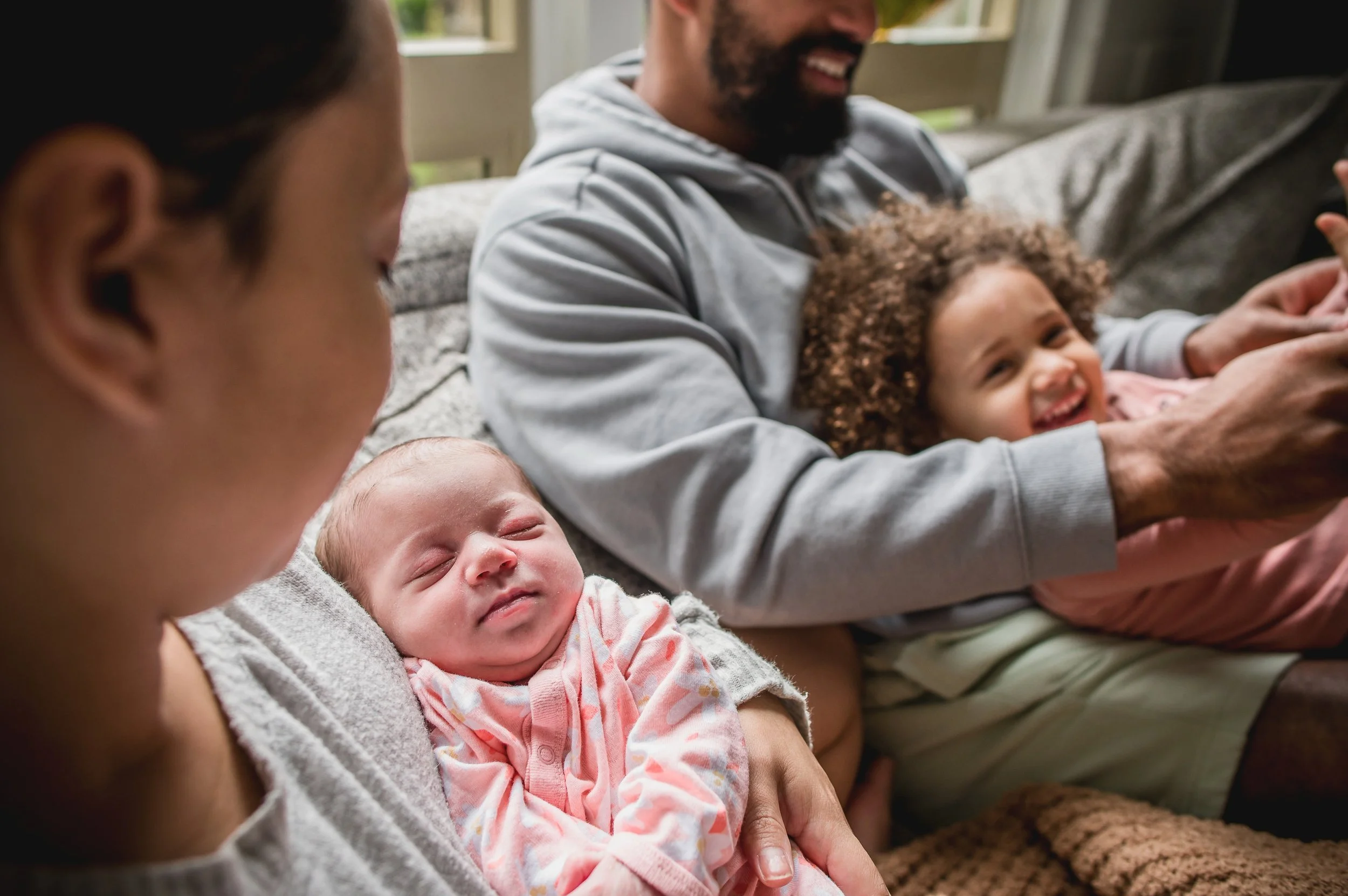 Sleepy baby in mamas arms while dad has the excited big sister who is full of energy.

This is family life with a little one and a newborn. Sometimes it looks like family naps, sweet cuddles and belly laughs and other times it looks like organized ch